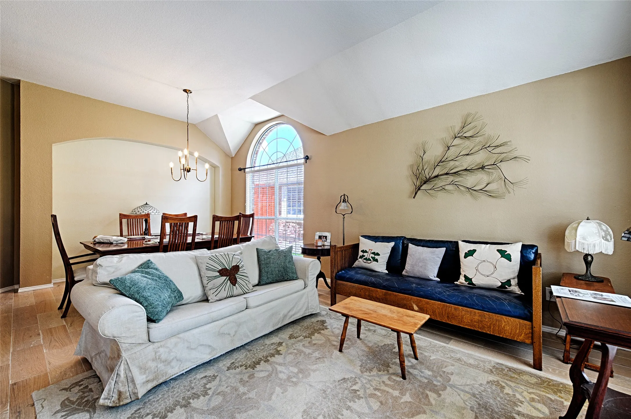 Vaulted ceiling living area featuring light wood-finish flooring