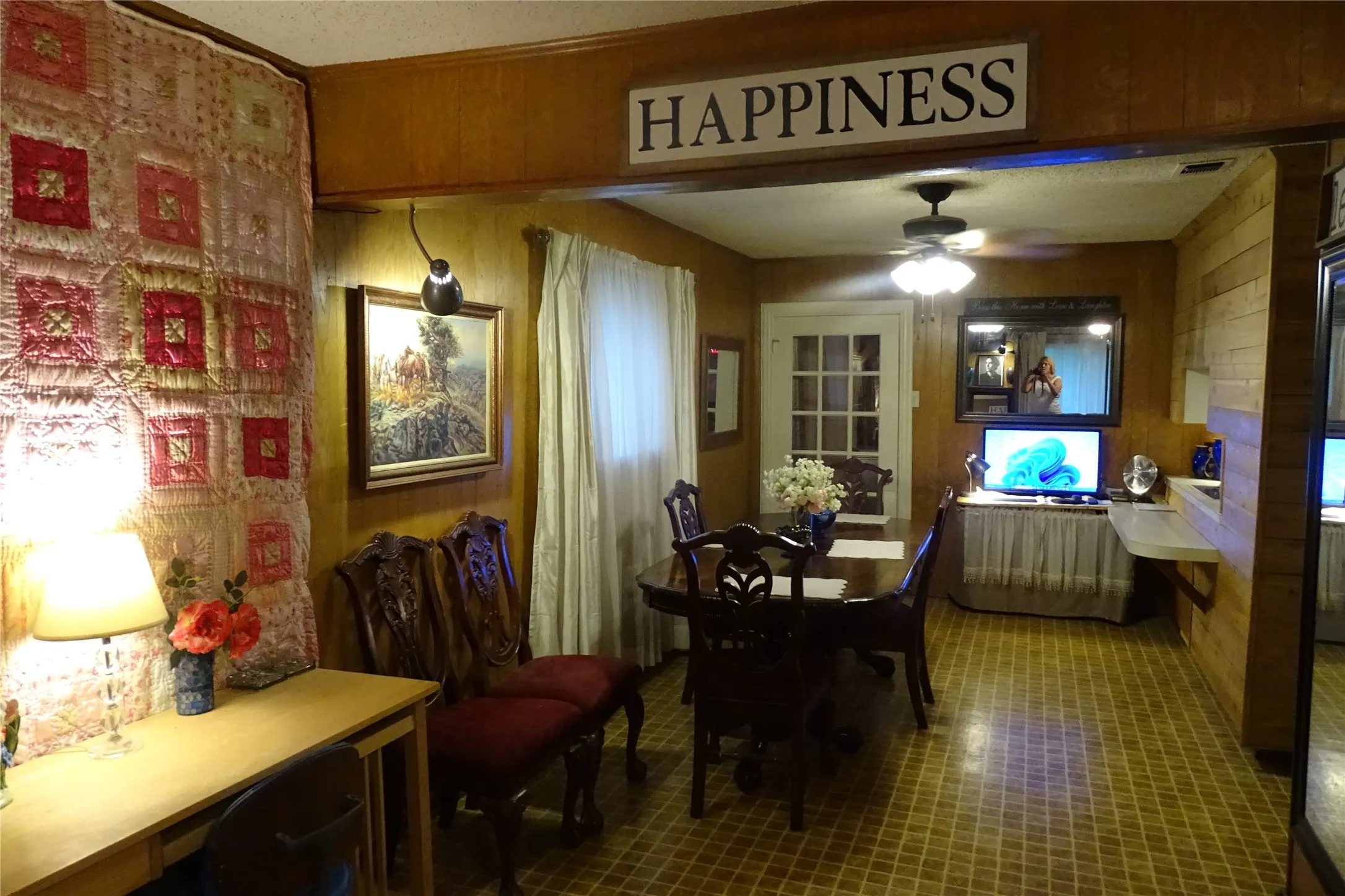 Room featuring wood paneling, a ceiling fan with integrated lighting, and a white paneled door with glass inserts