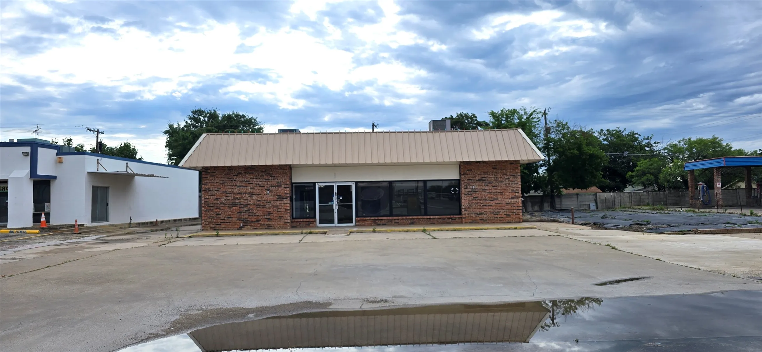 Commercial building featuring a brick facade and a metal roof