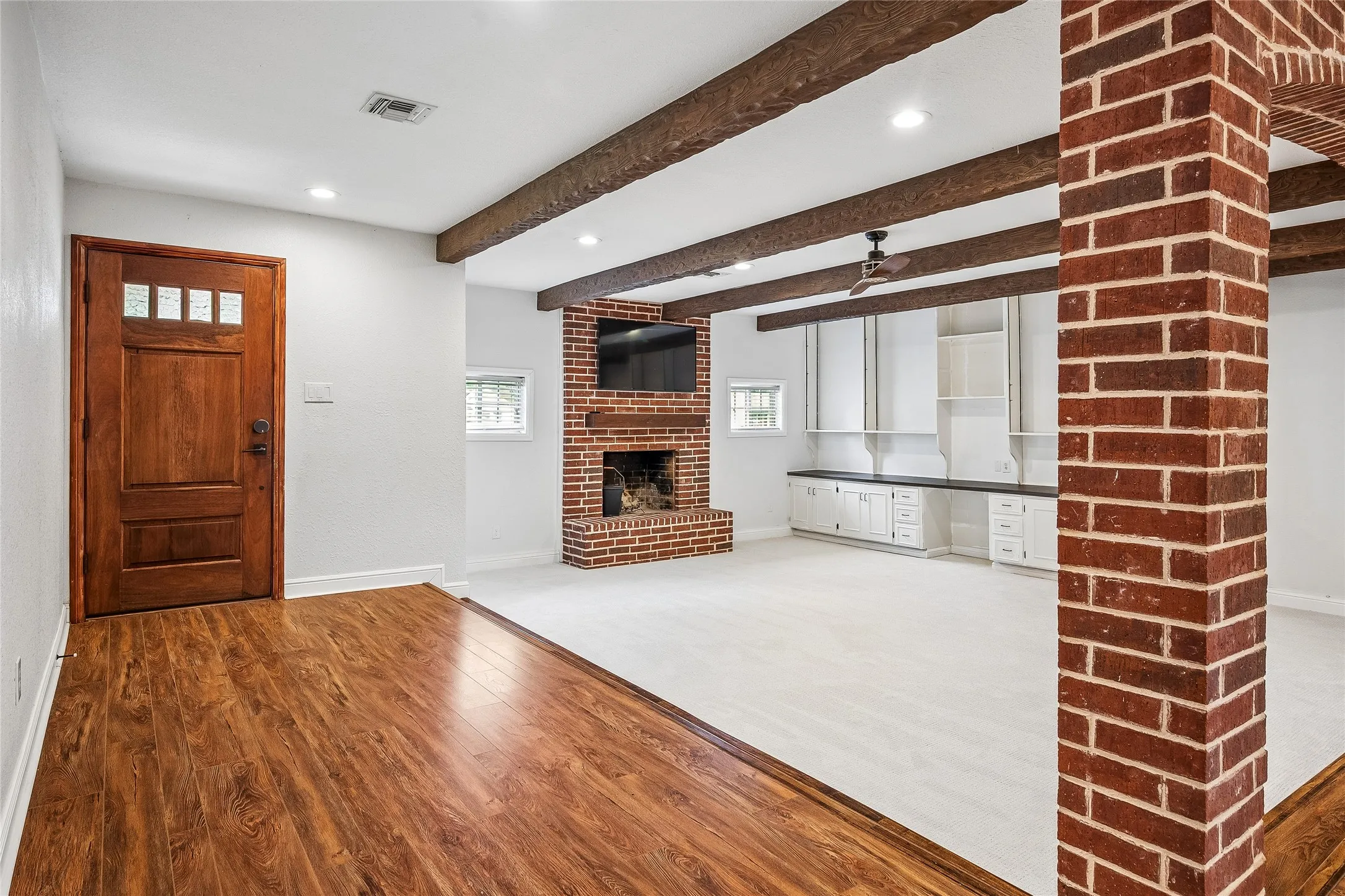 BVIRTUAL STAGING edroom featuring a rustic wood barn door, hardwood flooring, ceiling fan, and a window with horizontal blinds