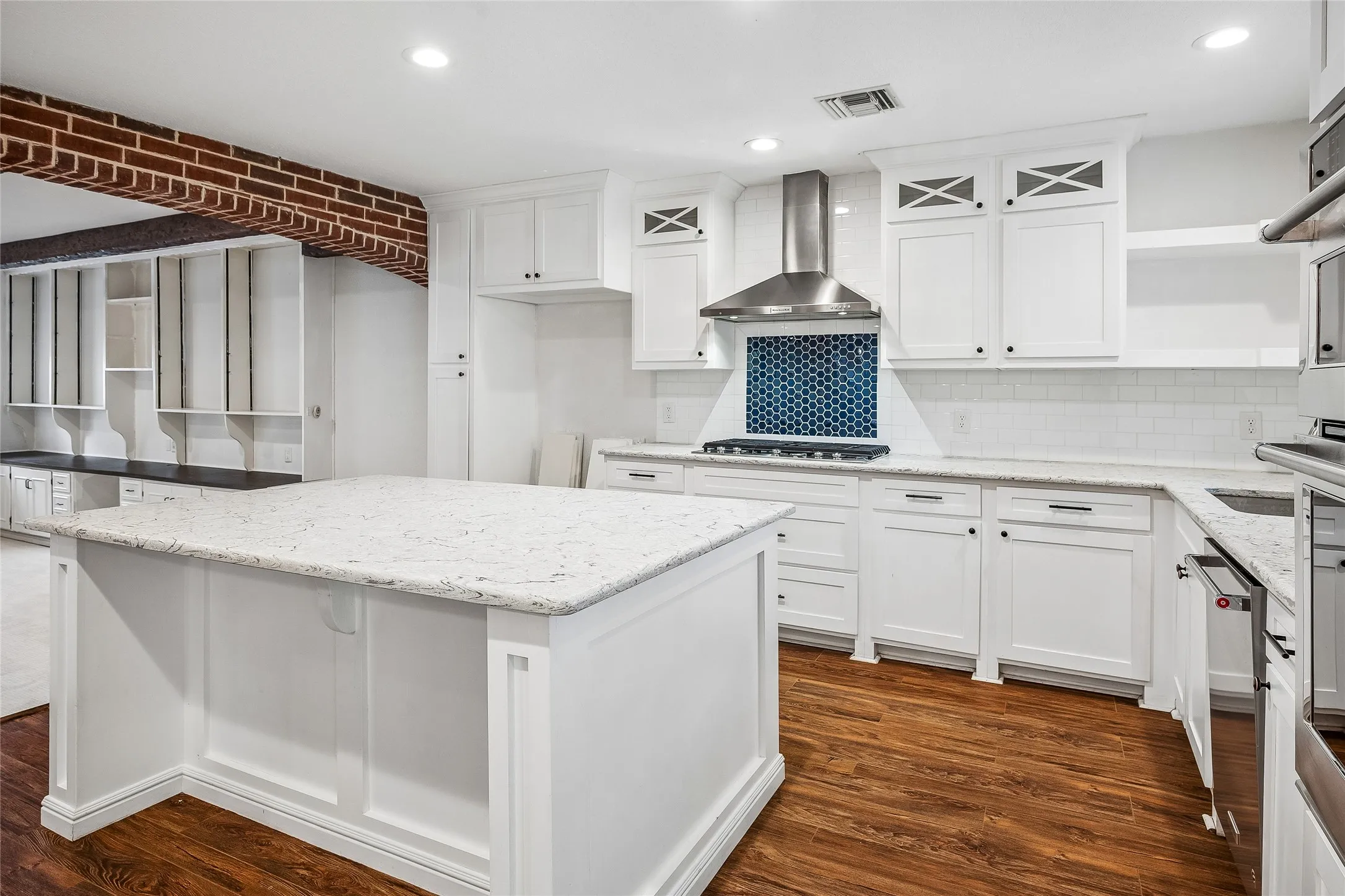 Open concept living space featuring a carpeted area with built-in white cabinetry and a dark wood-finish countertop
