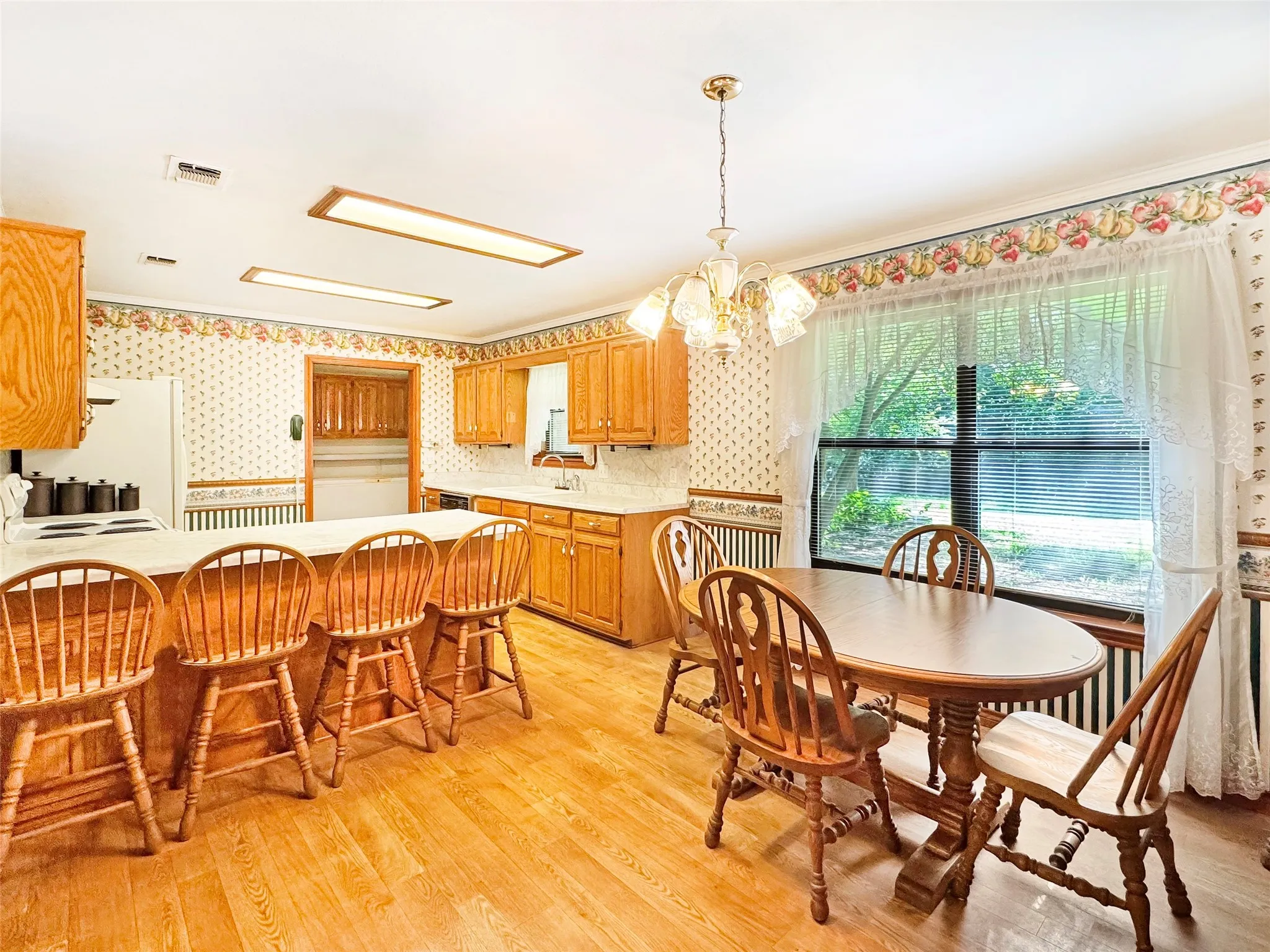Eat-in kitchen featuring wood-finish flooring and ample natural light from the large window