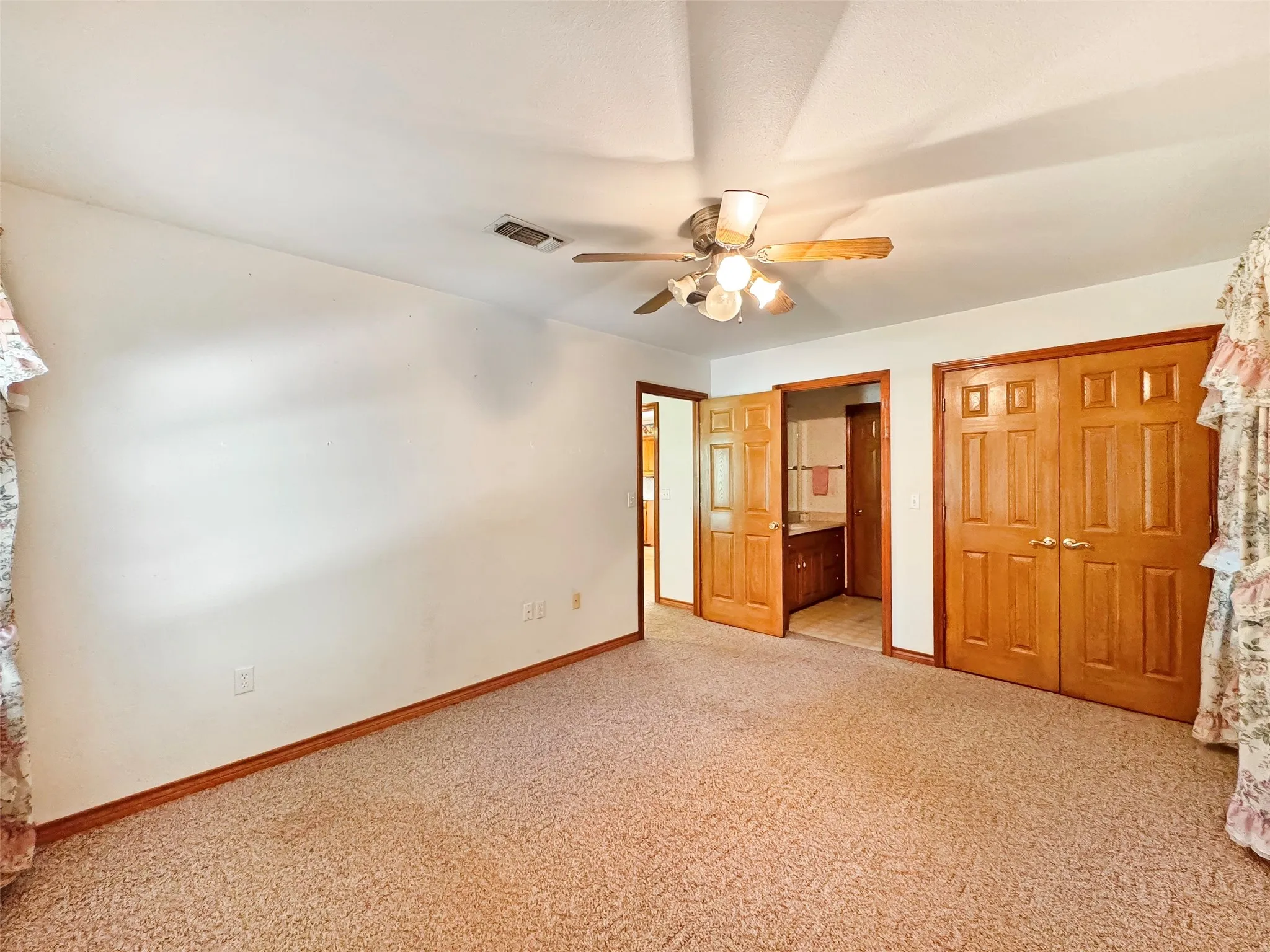 Carpeted room with light walls and wood-finish trim
