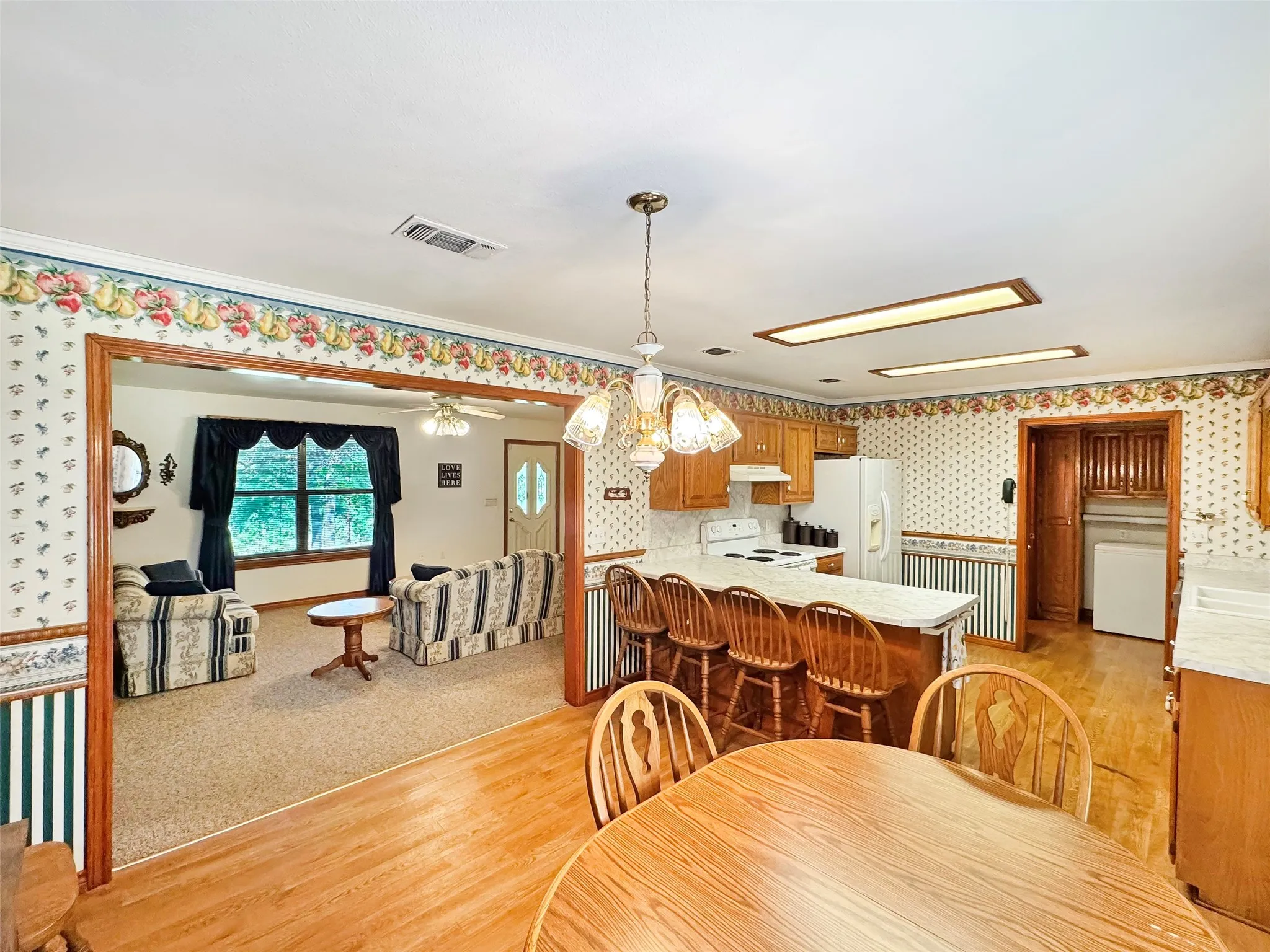 Kitchen featuring wood-finish flooring, a breakfast bar, recessed lighting, and wood cabinetry