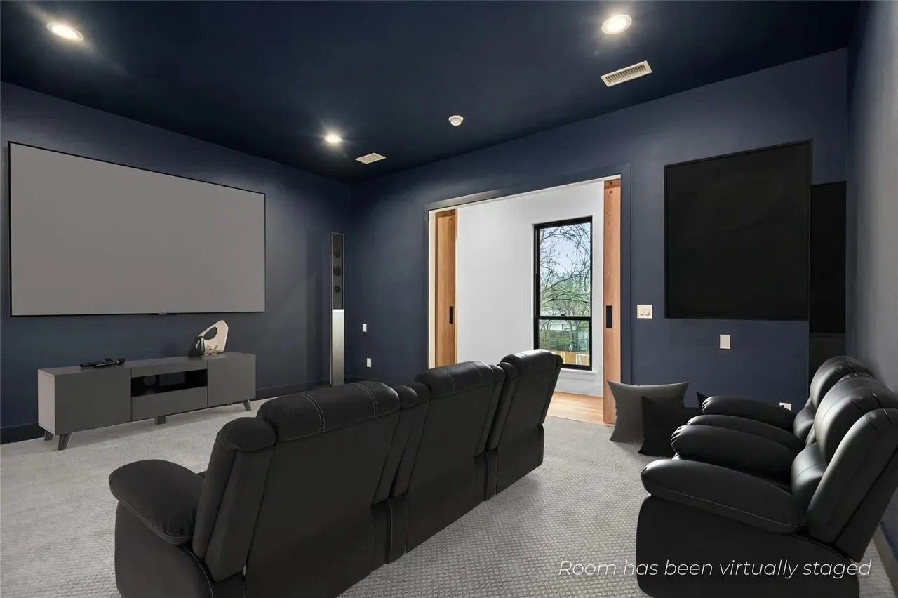 Media room featuring a large projection screen, recessed lighting, and a dark-painted ceiling