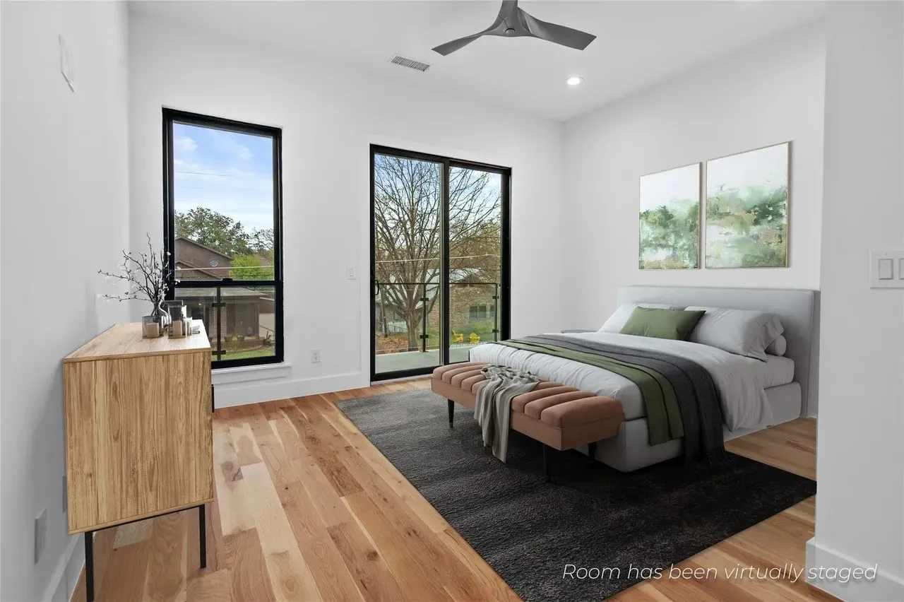 Bright room featuring wide plank wood-finish flooring, a modern ceiling fan, recessed lighting, and a full-height glass door opening to an exterior balcony