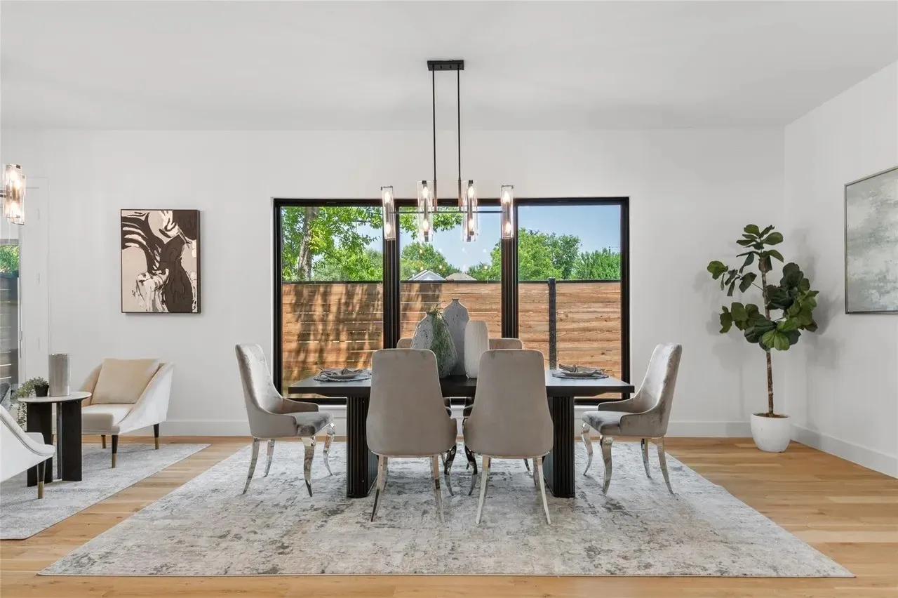 Dining area featuring light wood-finish flooring, white walls, and a contemporary linear chandelier