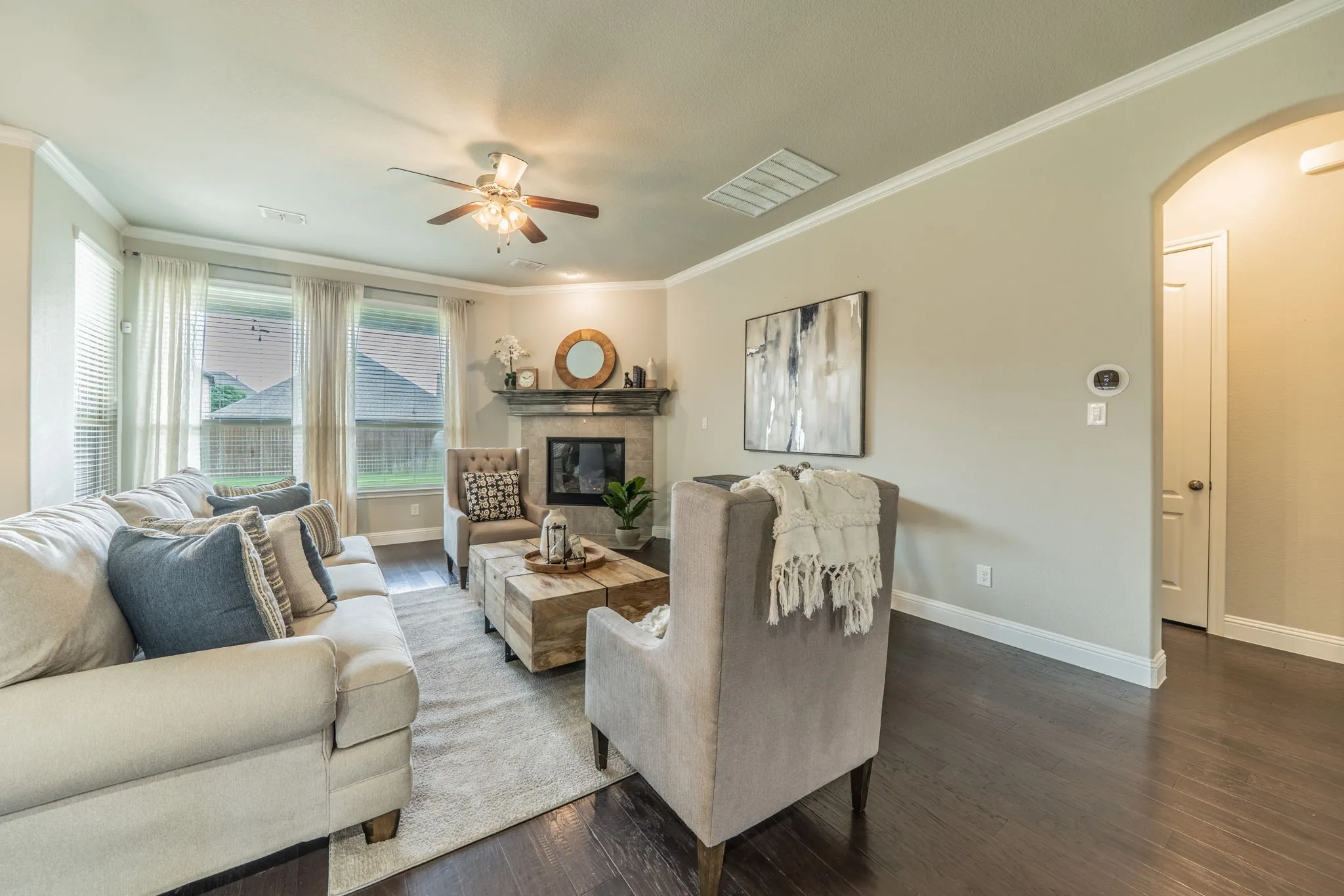 Big, bright windows look out to the covered patio. The private downstairs primary suite is just off the living room.