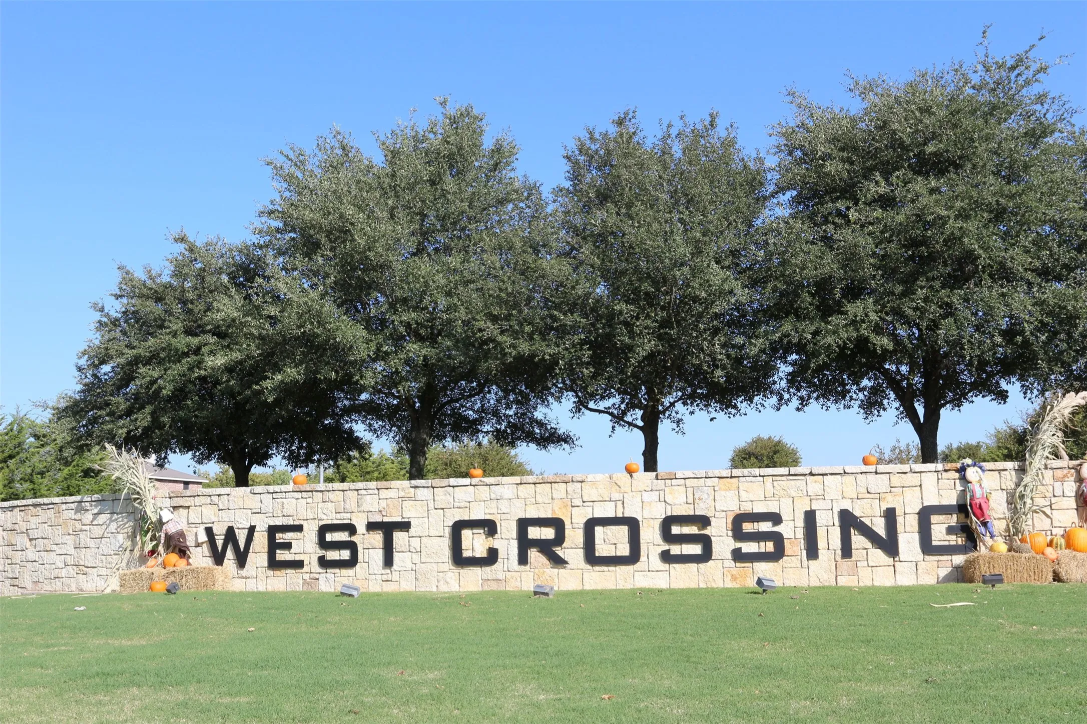 Community entry sign featuring stacked stone construction and prominent black lettering