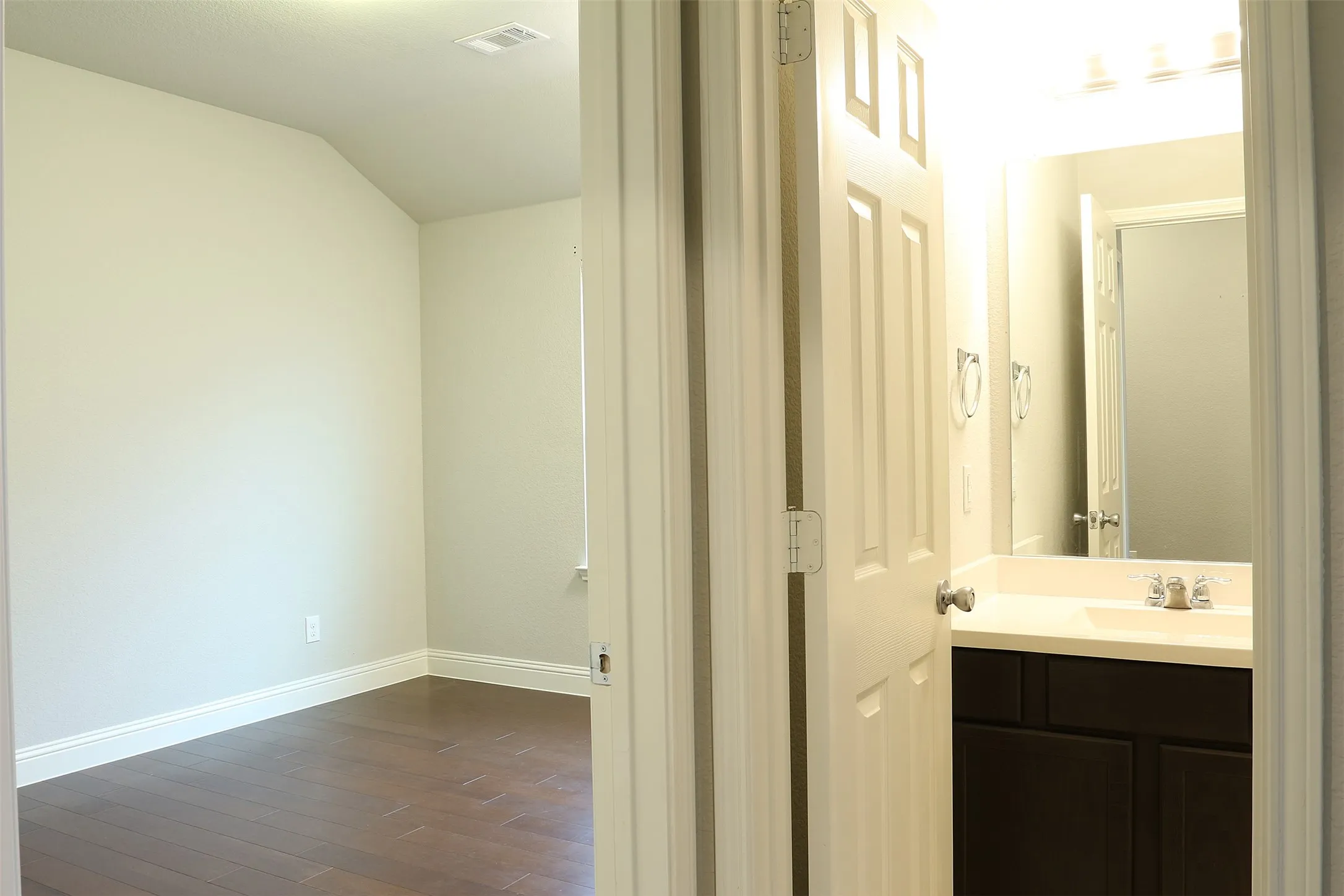Bathroom vanity with dark wood-finish cabinetry and a white countertop