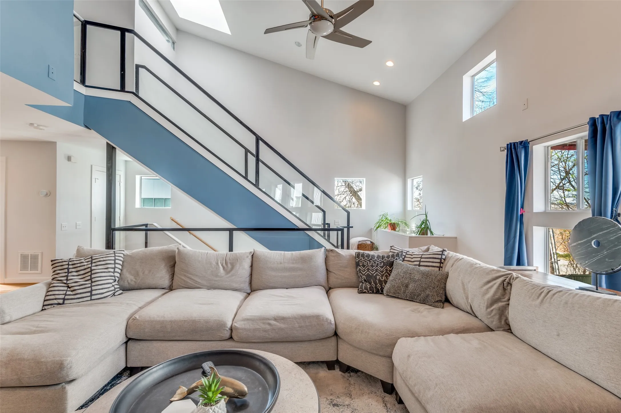 Light filled second floor living area with vaulted ceilings and oversized windows