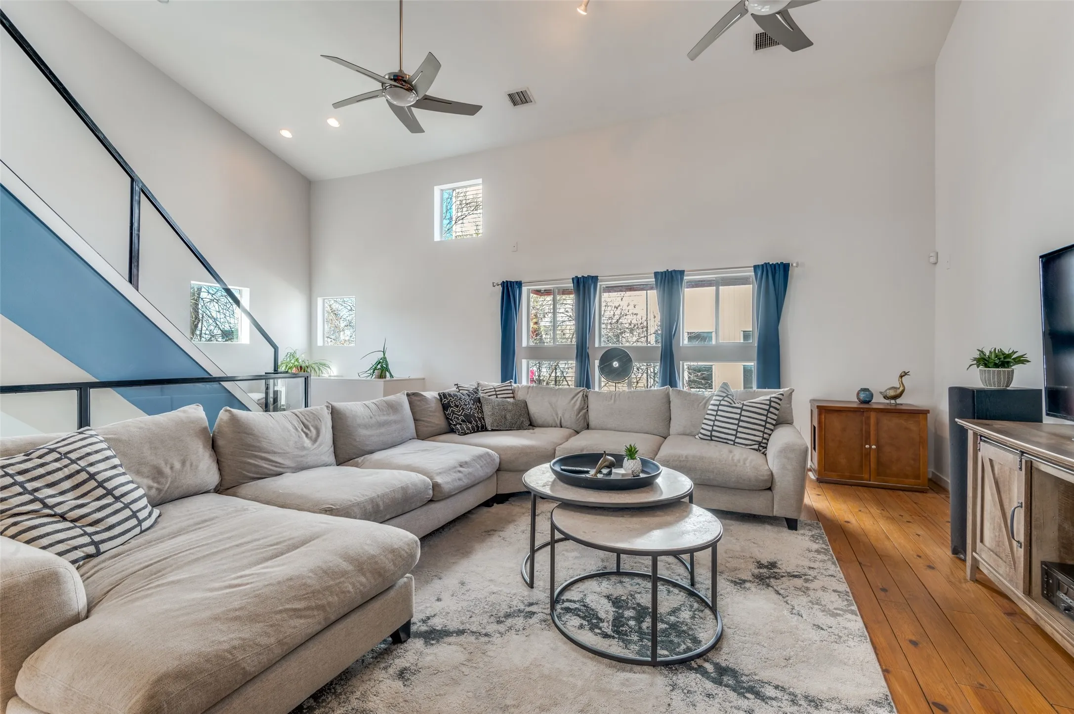 Light filled second floor living area with vaulted ceilings and oversized windows