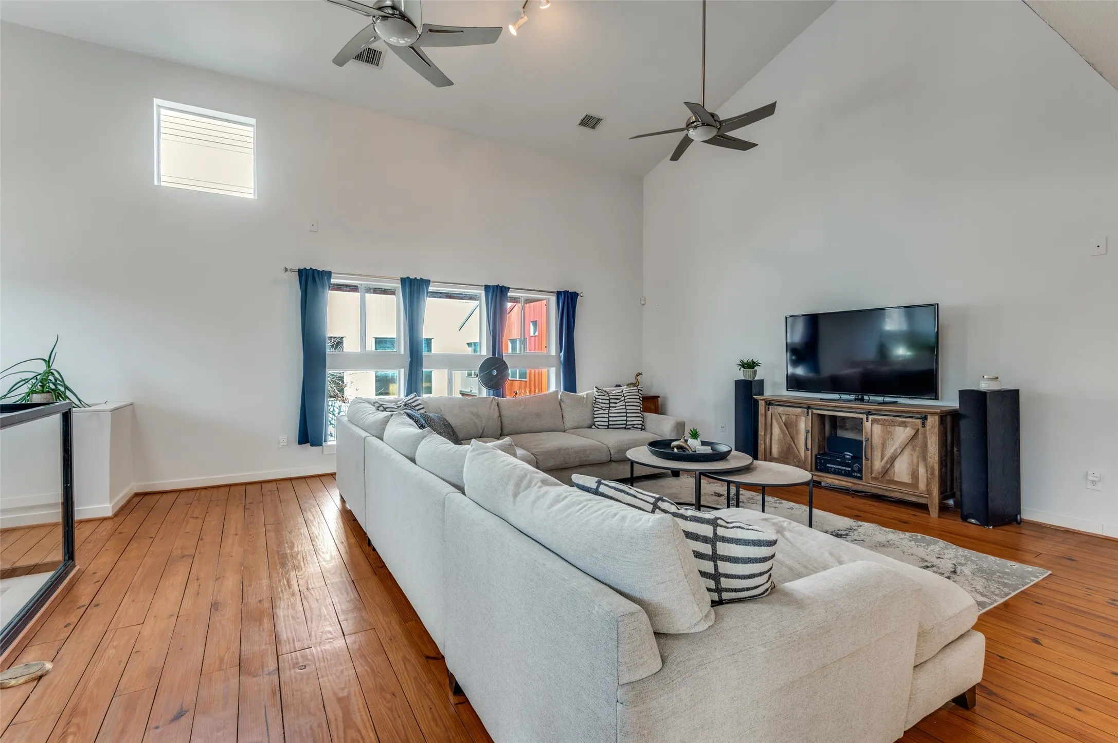 Light filled second floor living area with vaulted ceilings and oversized windows