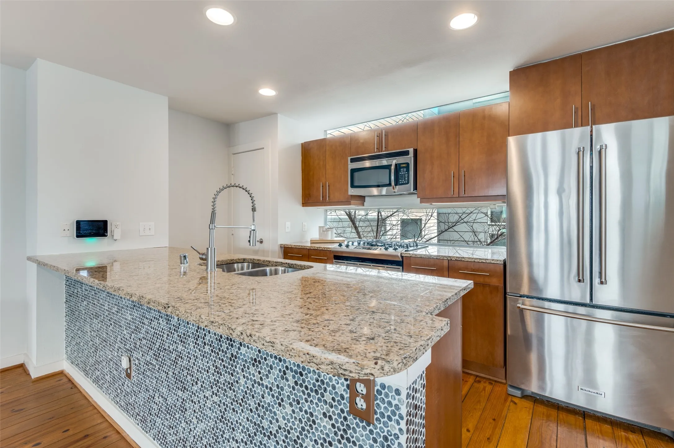 Chef’s kitchen with granite countertops, gas range, and breakfast bar seating