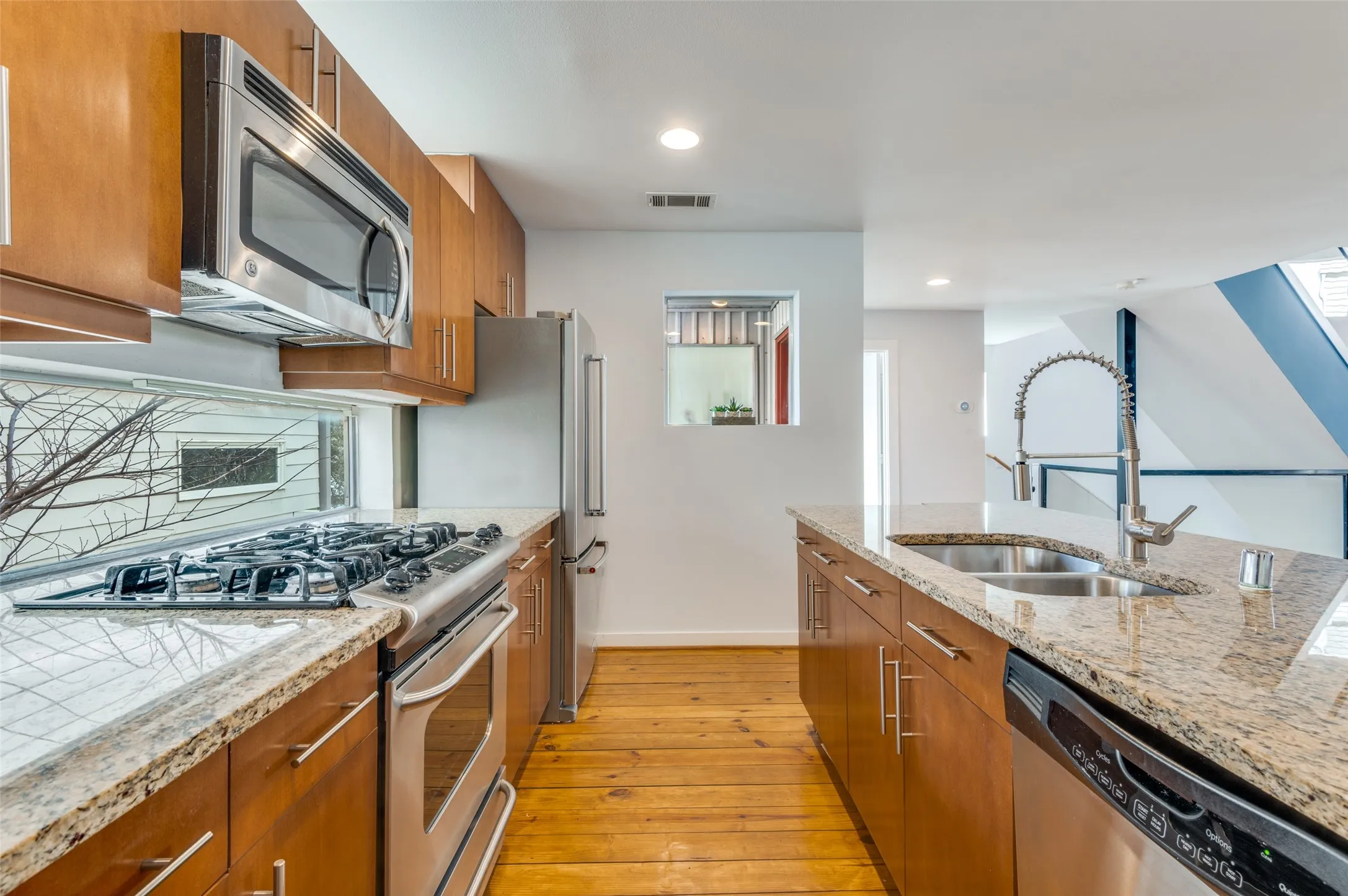 Chef’s kitchen with granite countertops, gas range, and breakfast bar seating