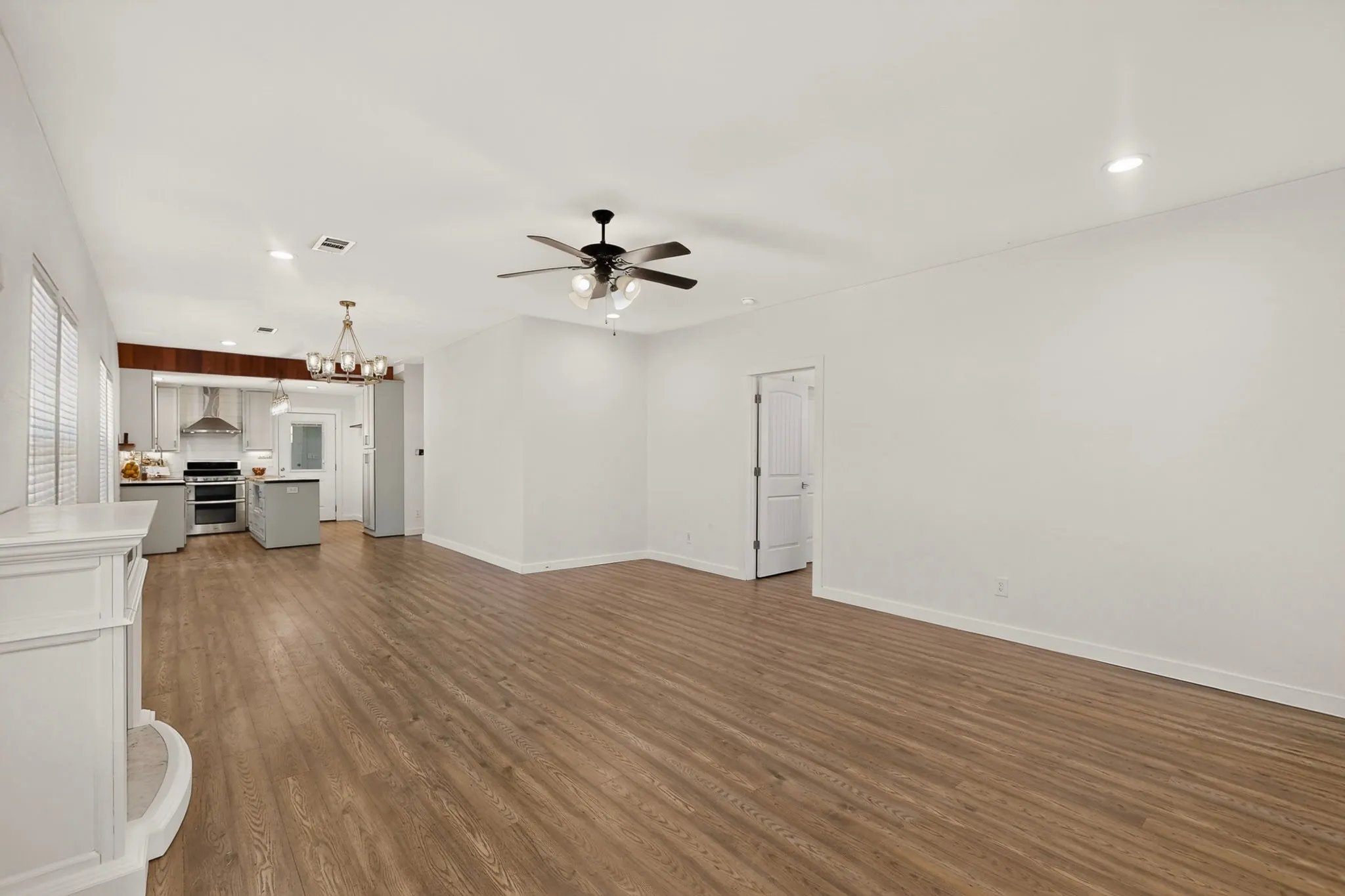 Open-concept living space featuring wood-finish flooring, recessed lighting, and a ceiling fan