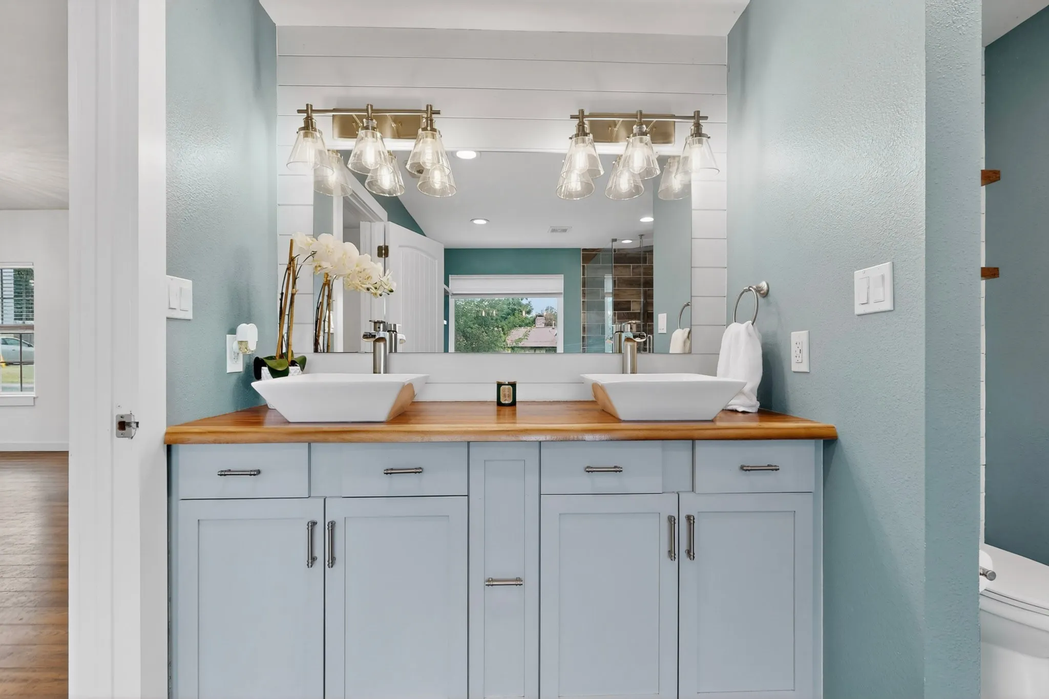 Walk-in shower featuring wood-finish tile, integrated shelving, and a rain shower head