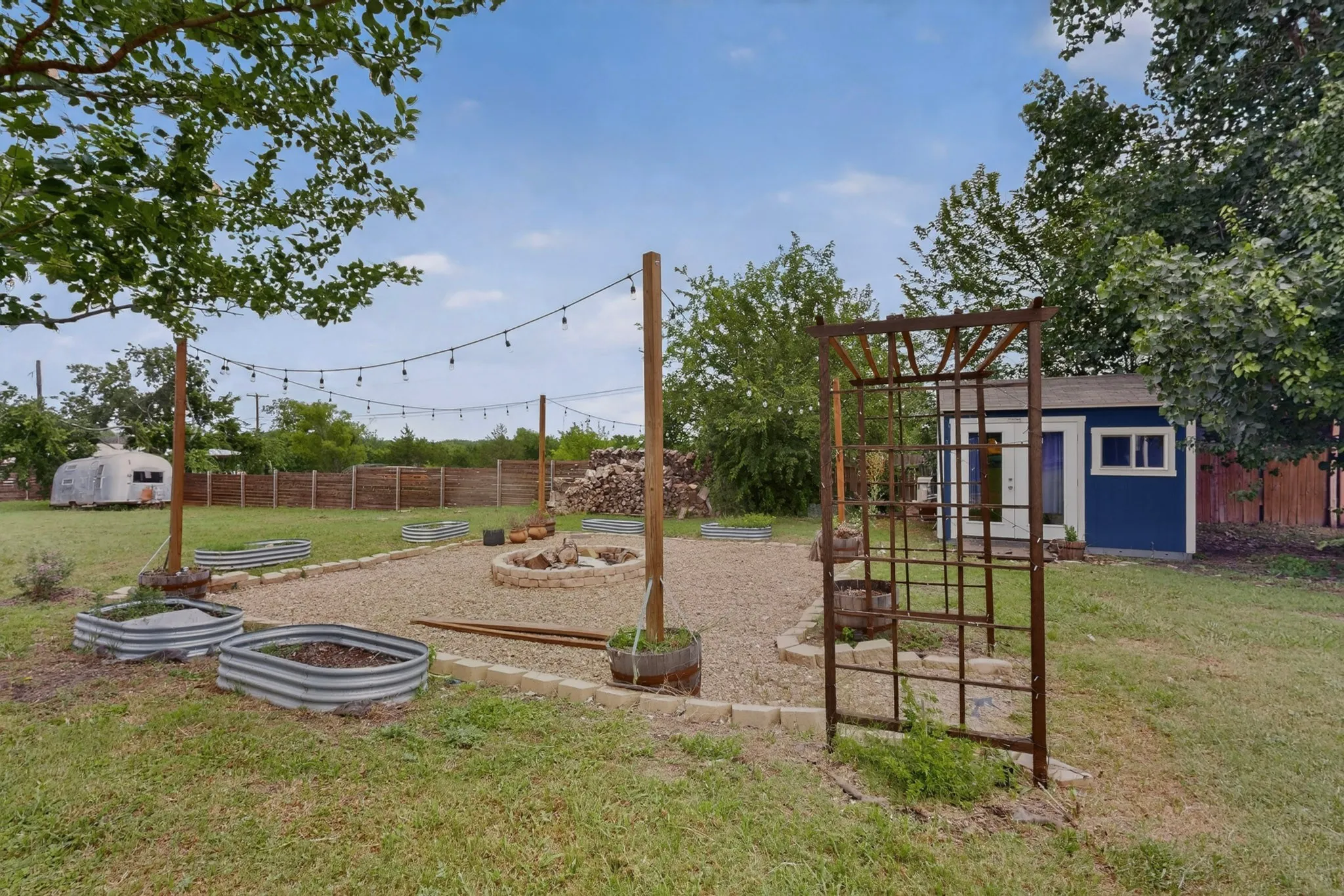 Expansive grassy yard encompassing the rear of the property, featuring a privacy fence, exterior siding, and a detached structure