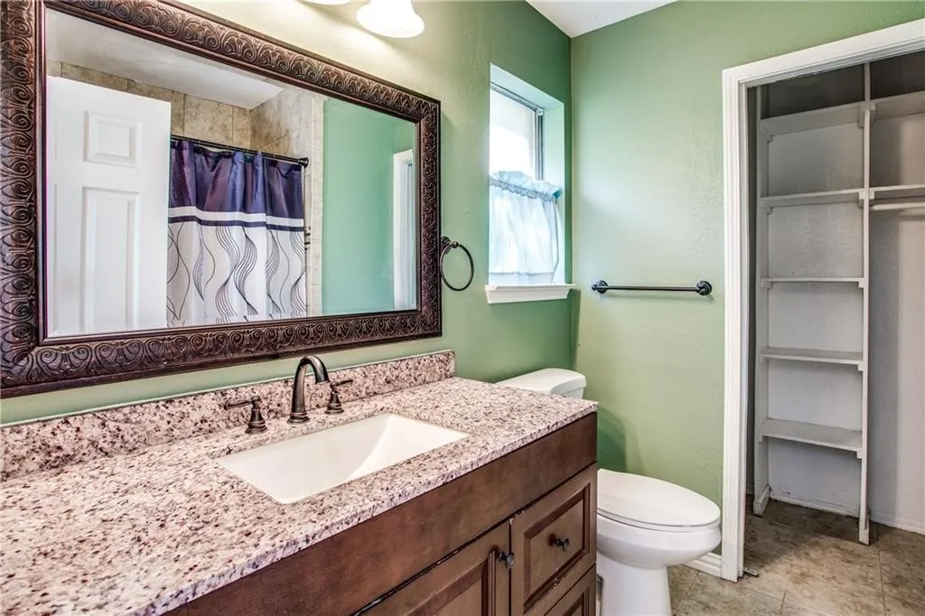 Bathroom featuring a vanity with a white rectangular undermount sink, a bronze-finish faucet, and a speckled countertop