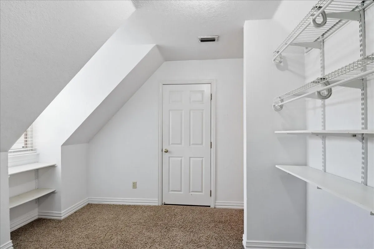 Carpeted flex/game
room with light colored walls, white trim, and a ceiling fan