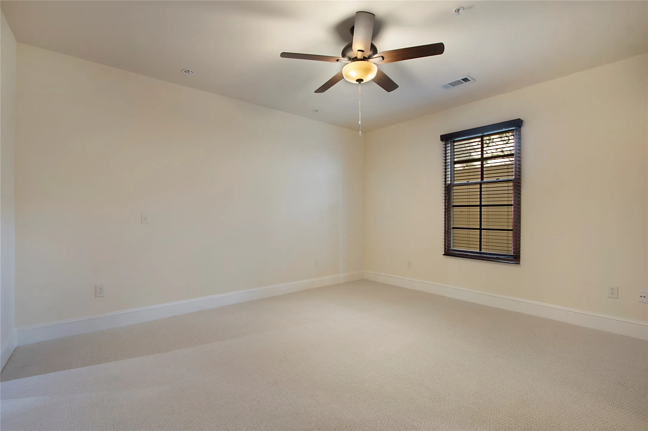 Carpeted empty room featuring ceiling fan