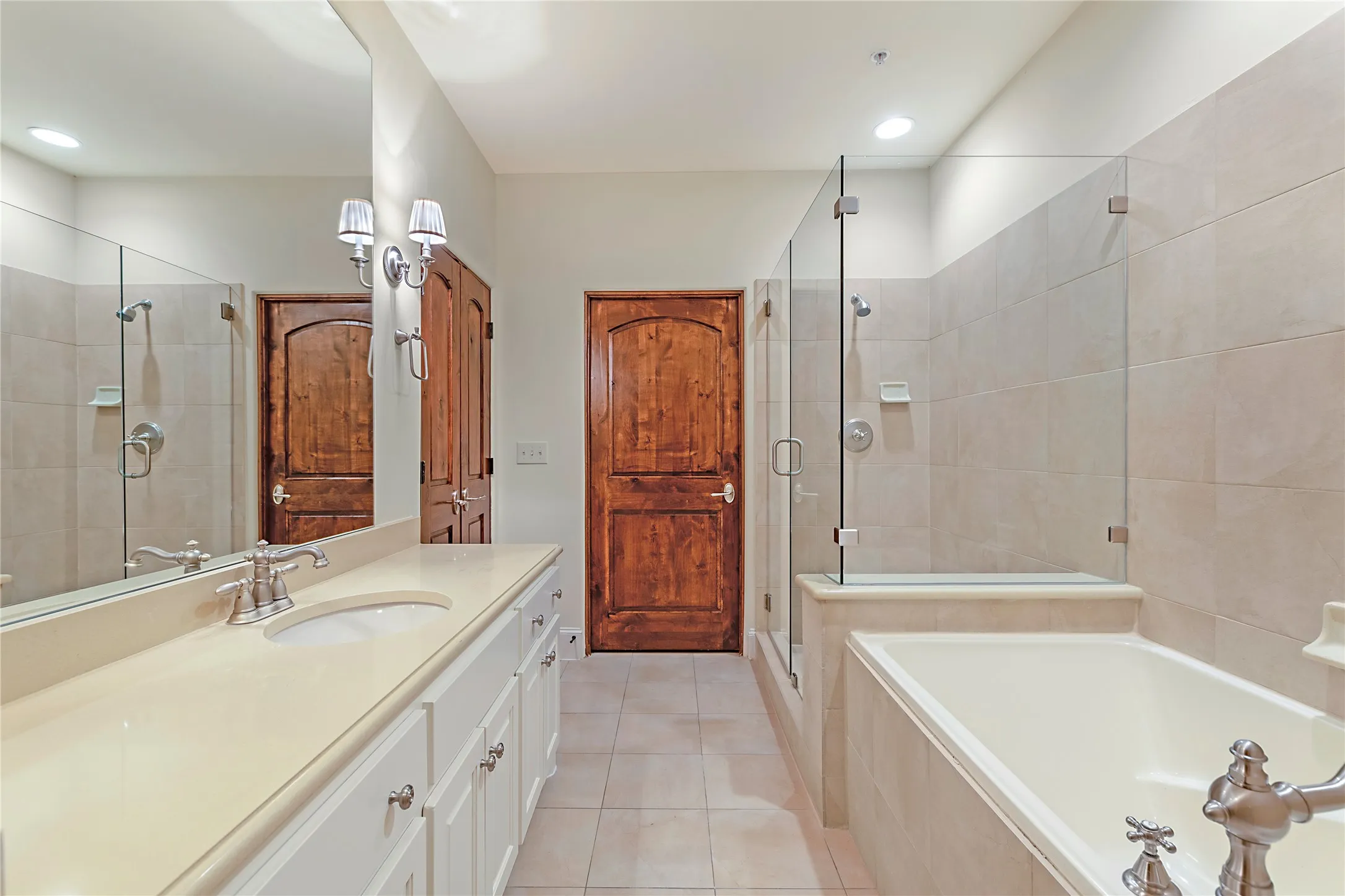 Bathroom featuring tile patterned flooring, vanity, and separate shower and tub