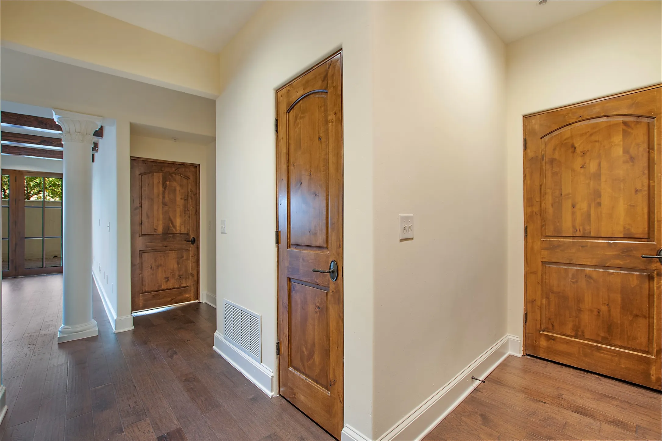 Entryway with decorative columns and hardwood / wood-style floors