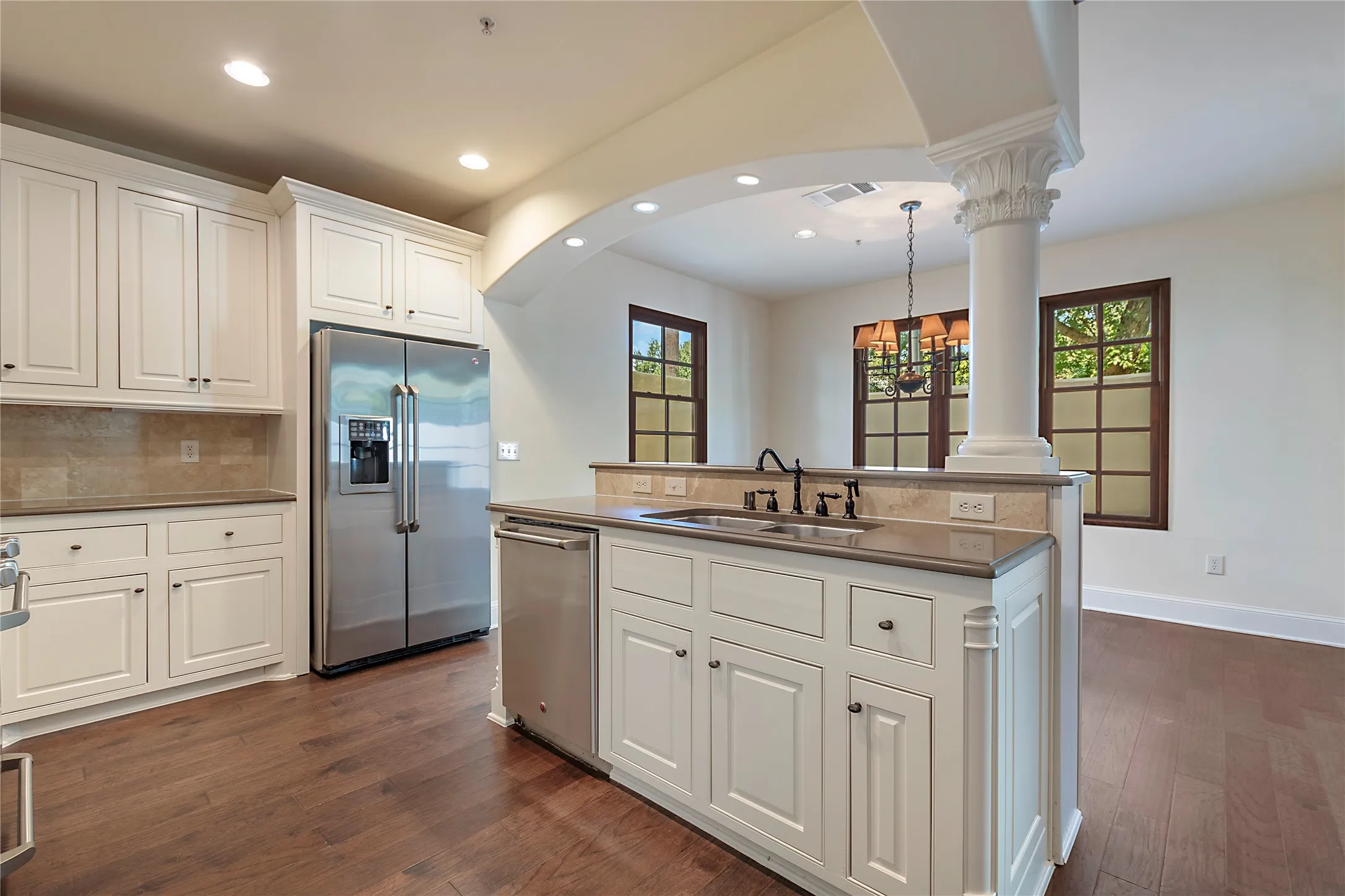 Kitchen featuring appliances with stainless steel finishes, ornate columns, sink, and plenty of natural light