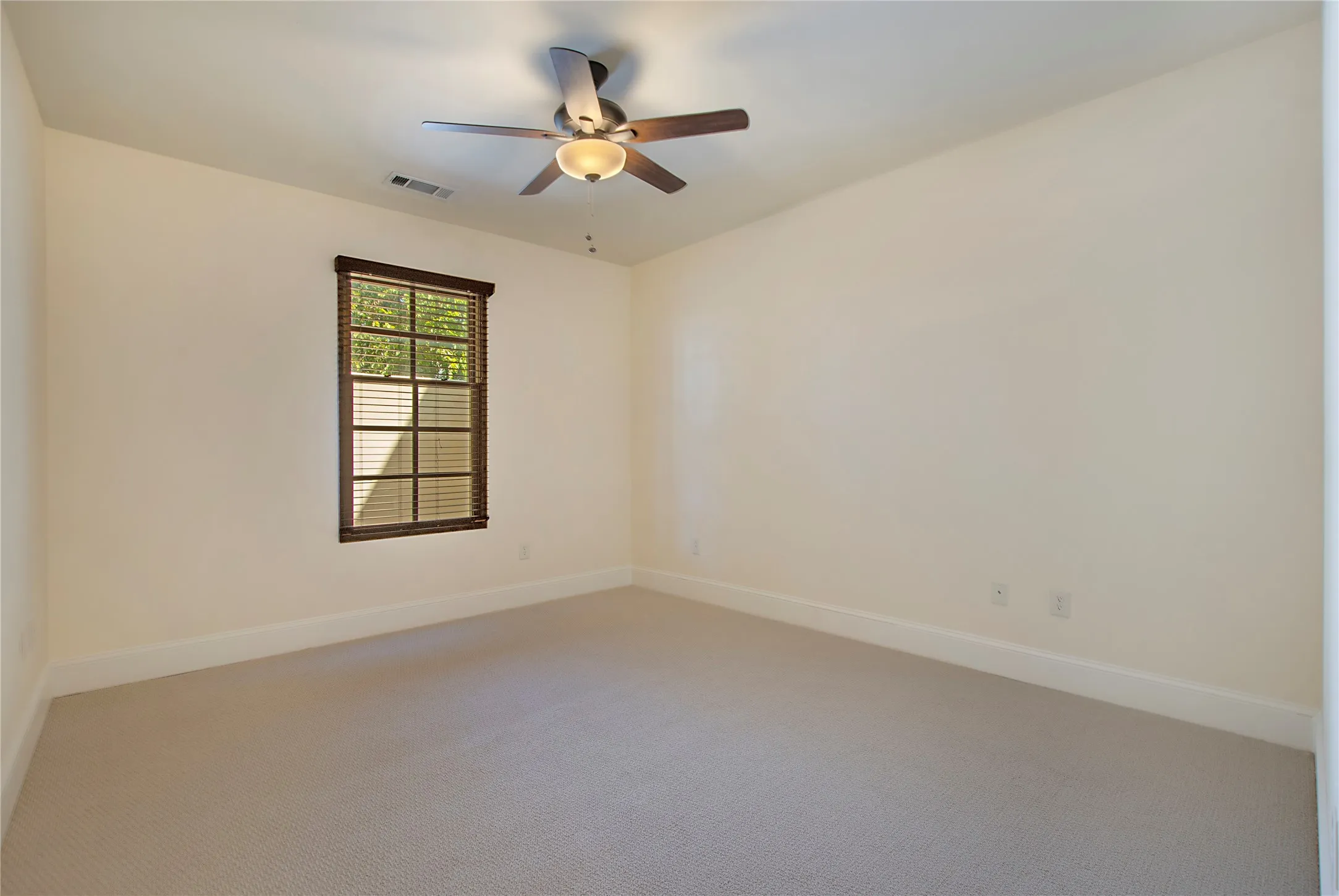 Carpeted empty room with ceiling fan