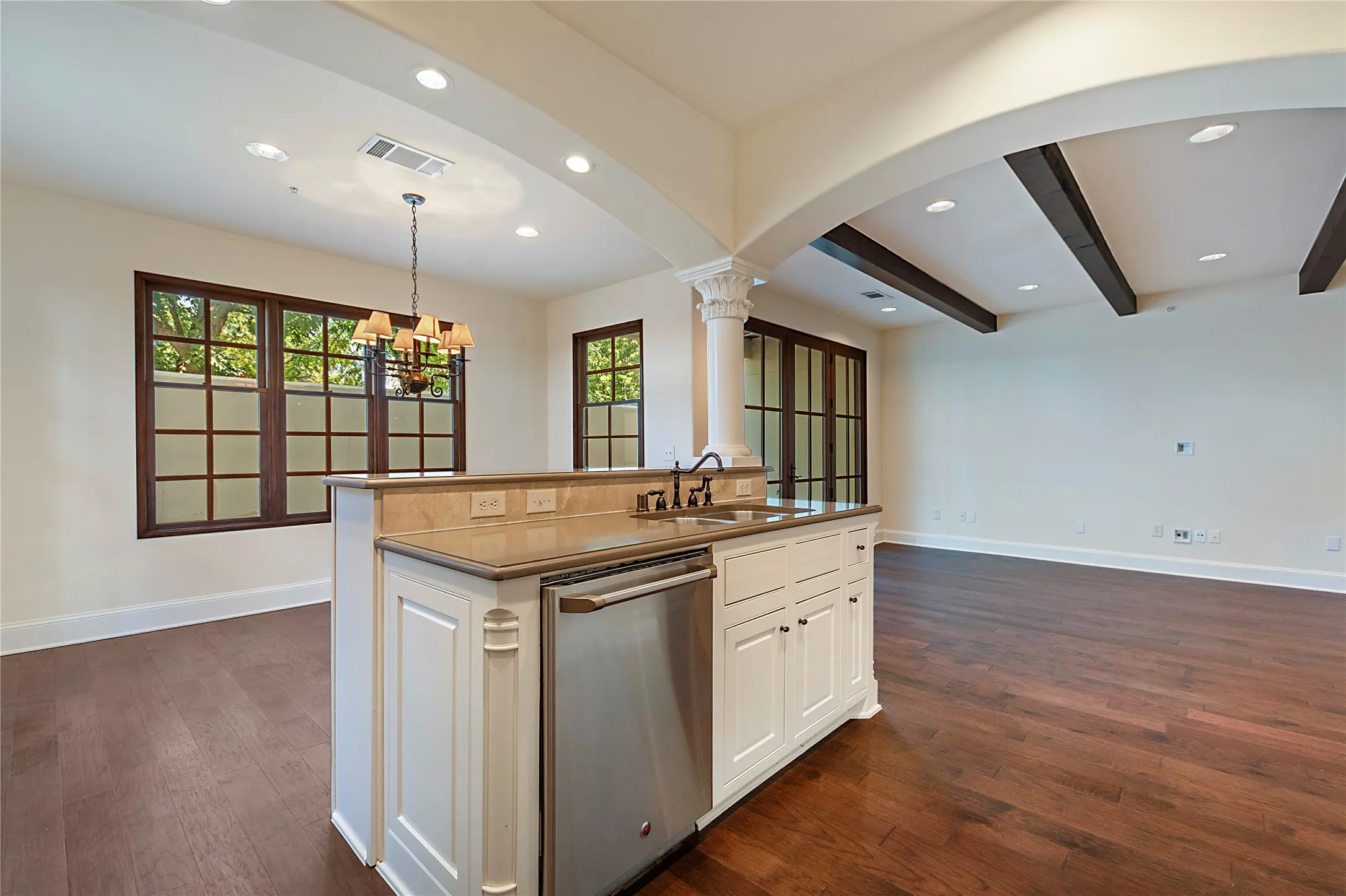 Kitchen with a wealth of natural light, dishwasher, sink, and ornate columns