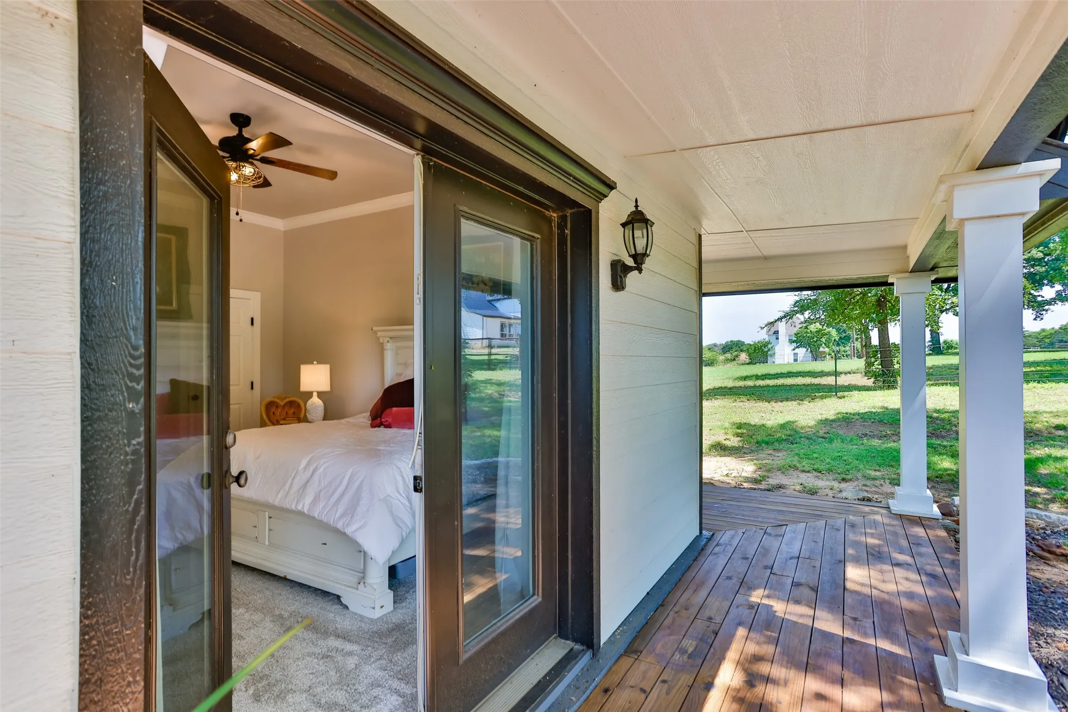 Glass Door Out Of Primary Bedroom to The Covered Front Porch Overlooking The Parklike Front Yard