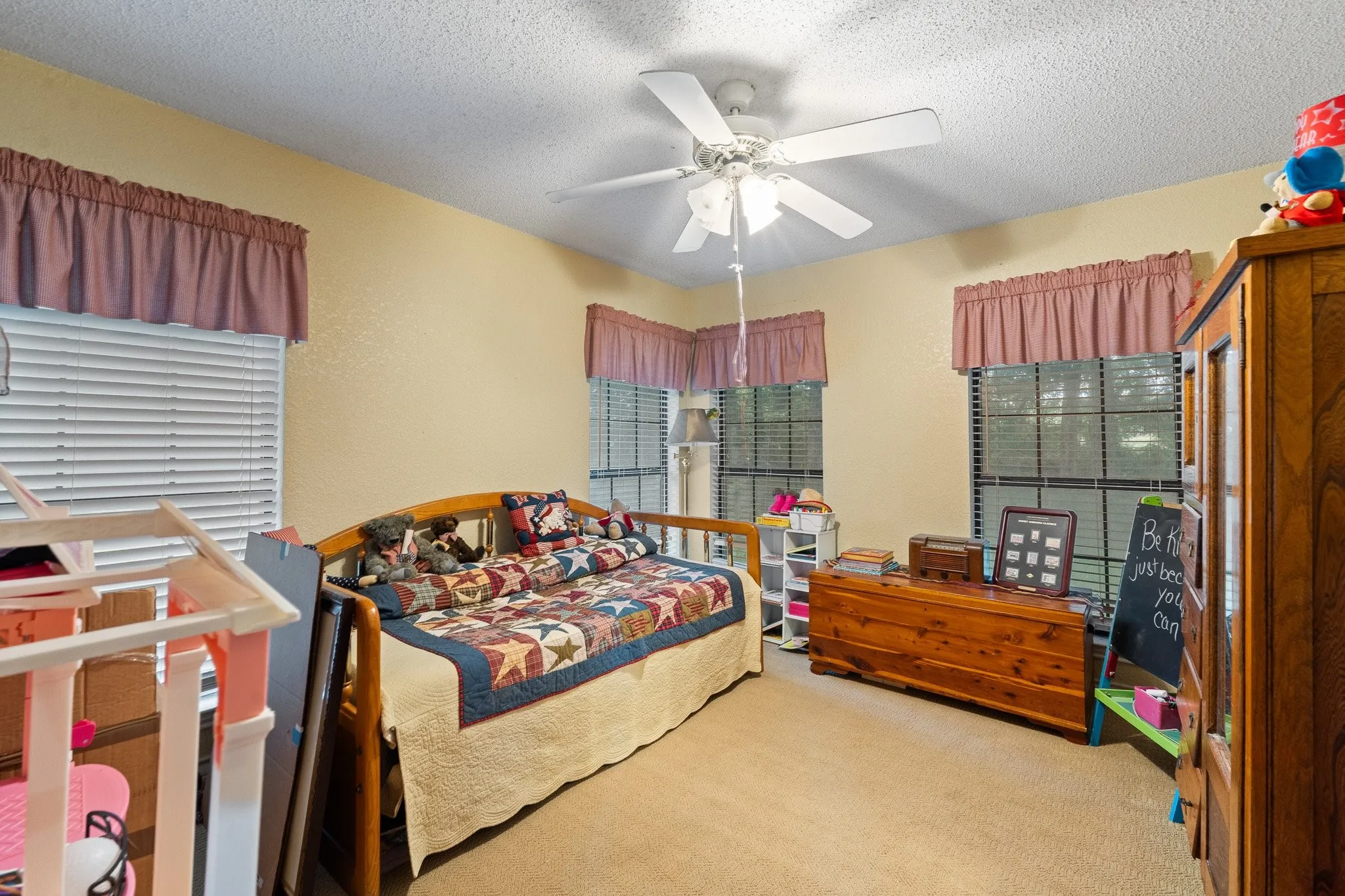 This bedroom so much natural light through 4 windows!