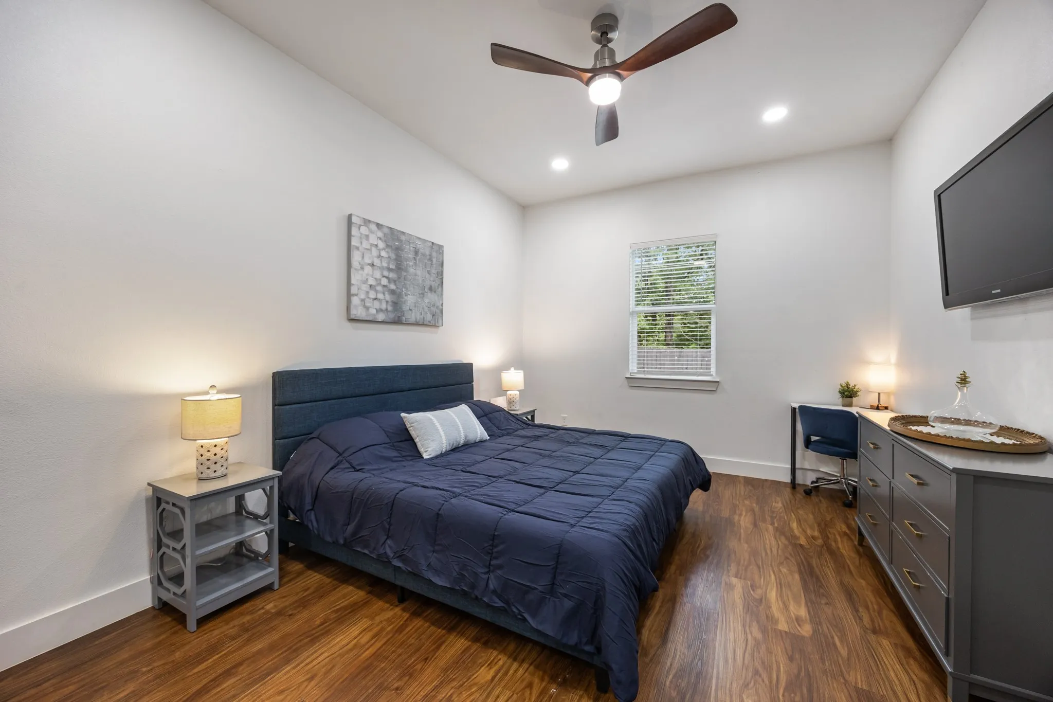 Bright room featuring wood-finish flooring, a contemporary ceiling fan, and recessed lighting