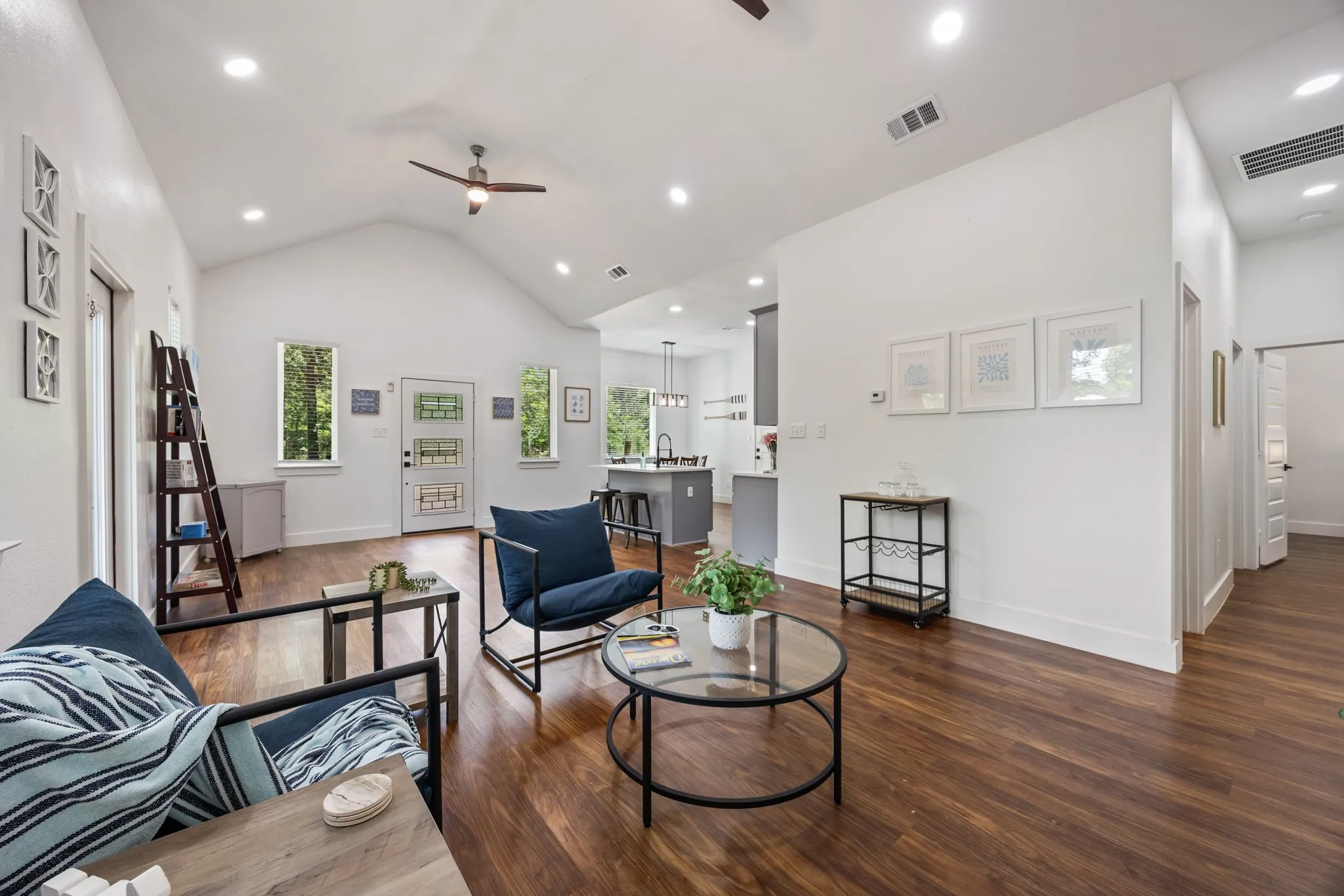 Vaulted ceiling living area featuring wood-finish flooring, recessed lighting, and a ceiling fan