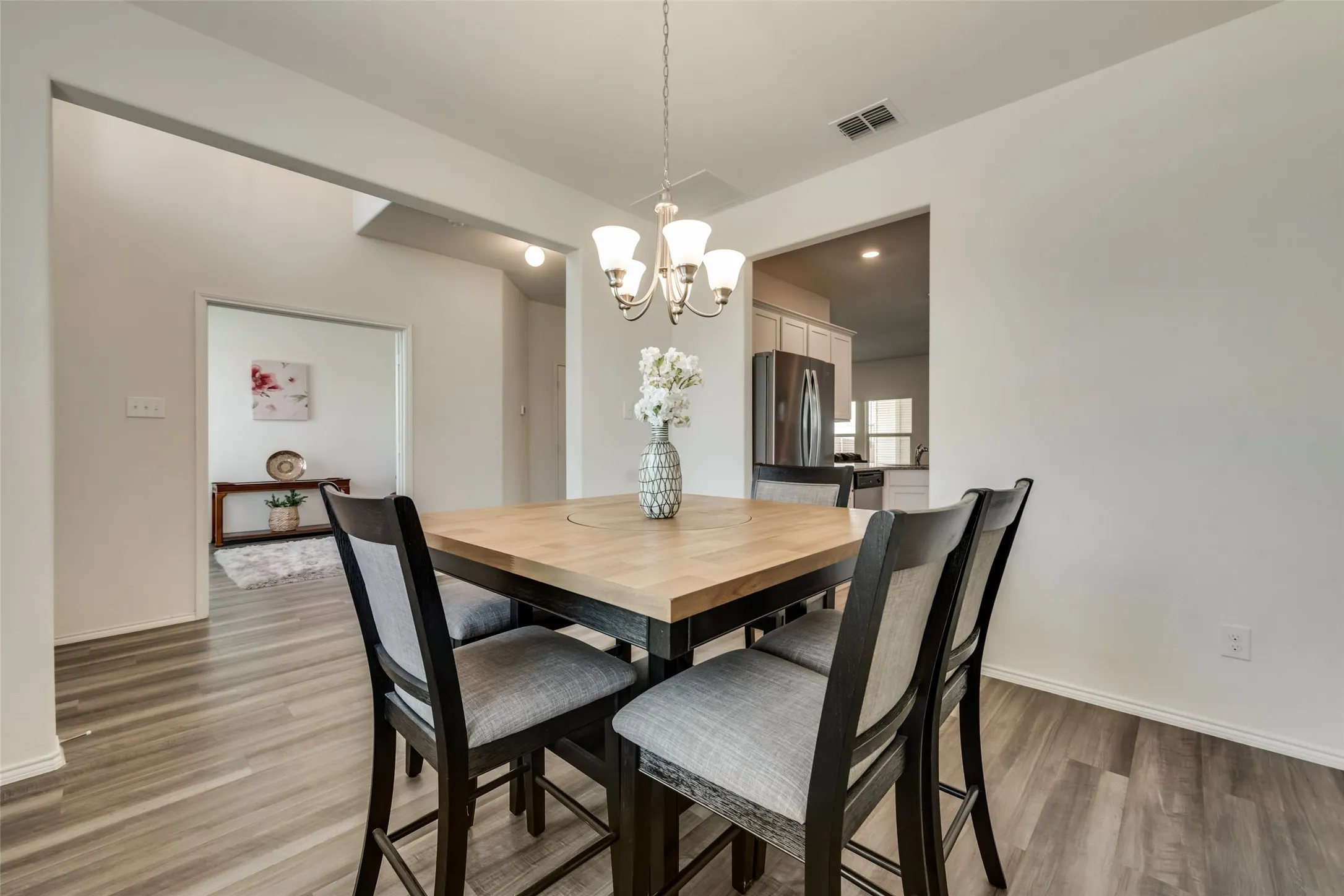 Dining area featuring wood-finish flooring and a central chandelier