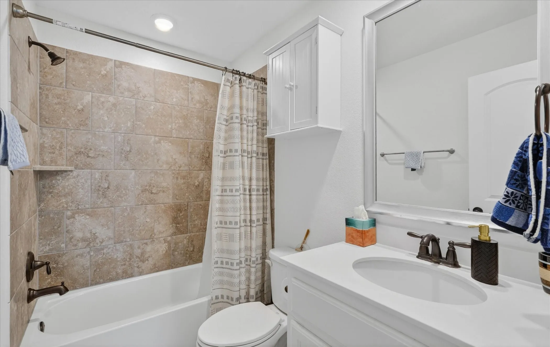 Bathroom featuring a white vanity with an undermount sink, a framed mirror, and a built-in medicine cabinet