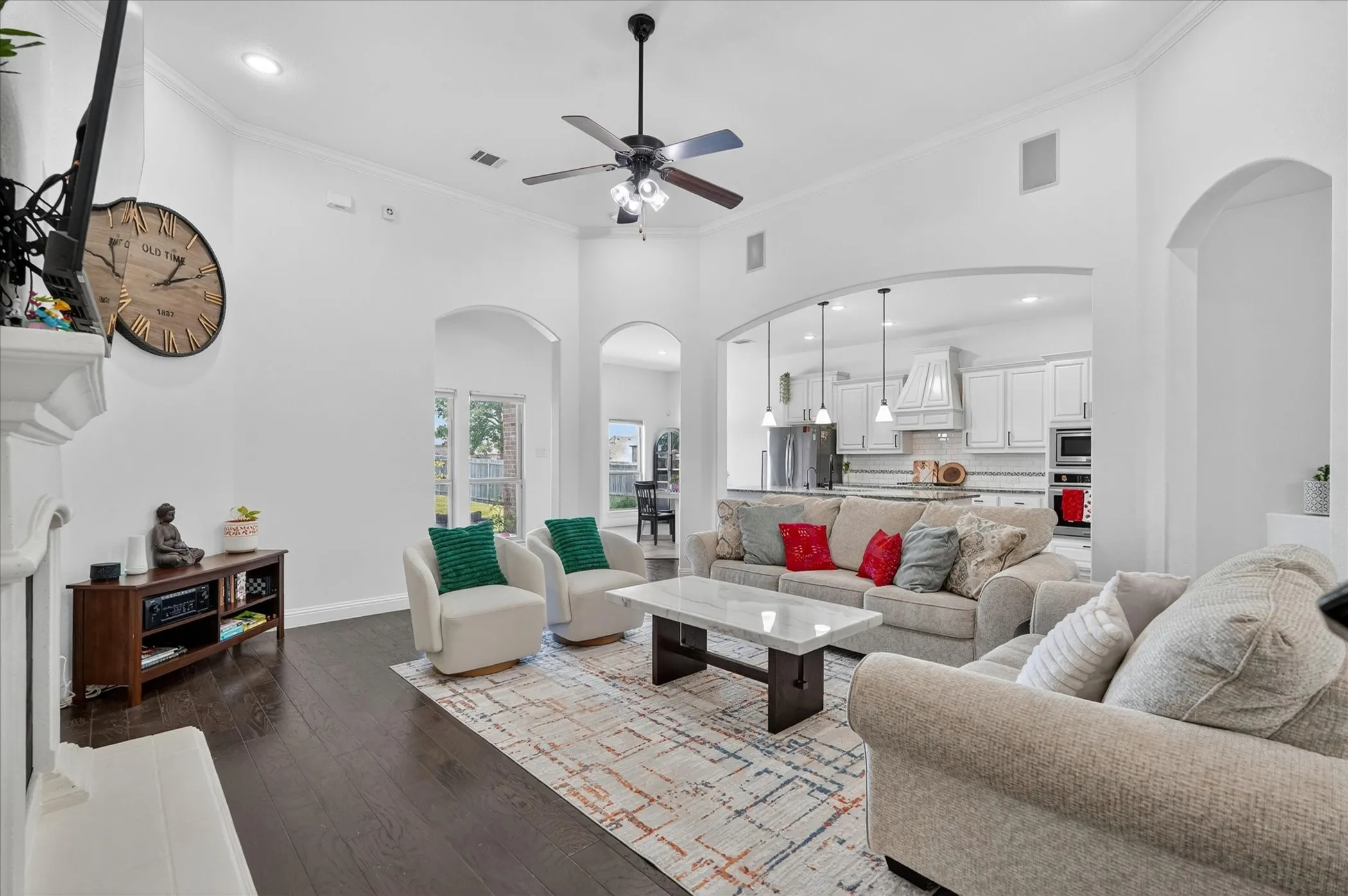 Spacious living area featuring dark wood-finish flooring, vaulted ceilings, and recessed lighting