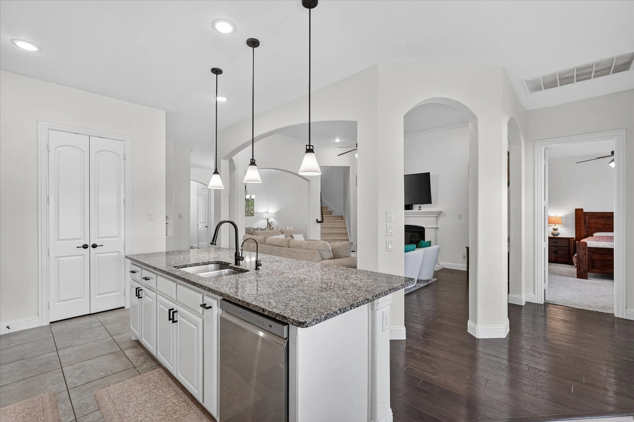 Kitchen island featuring granite countertops, a stainless steel sink, and a matte black faucet