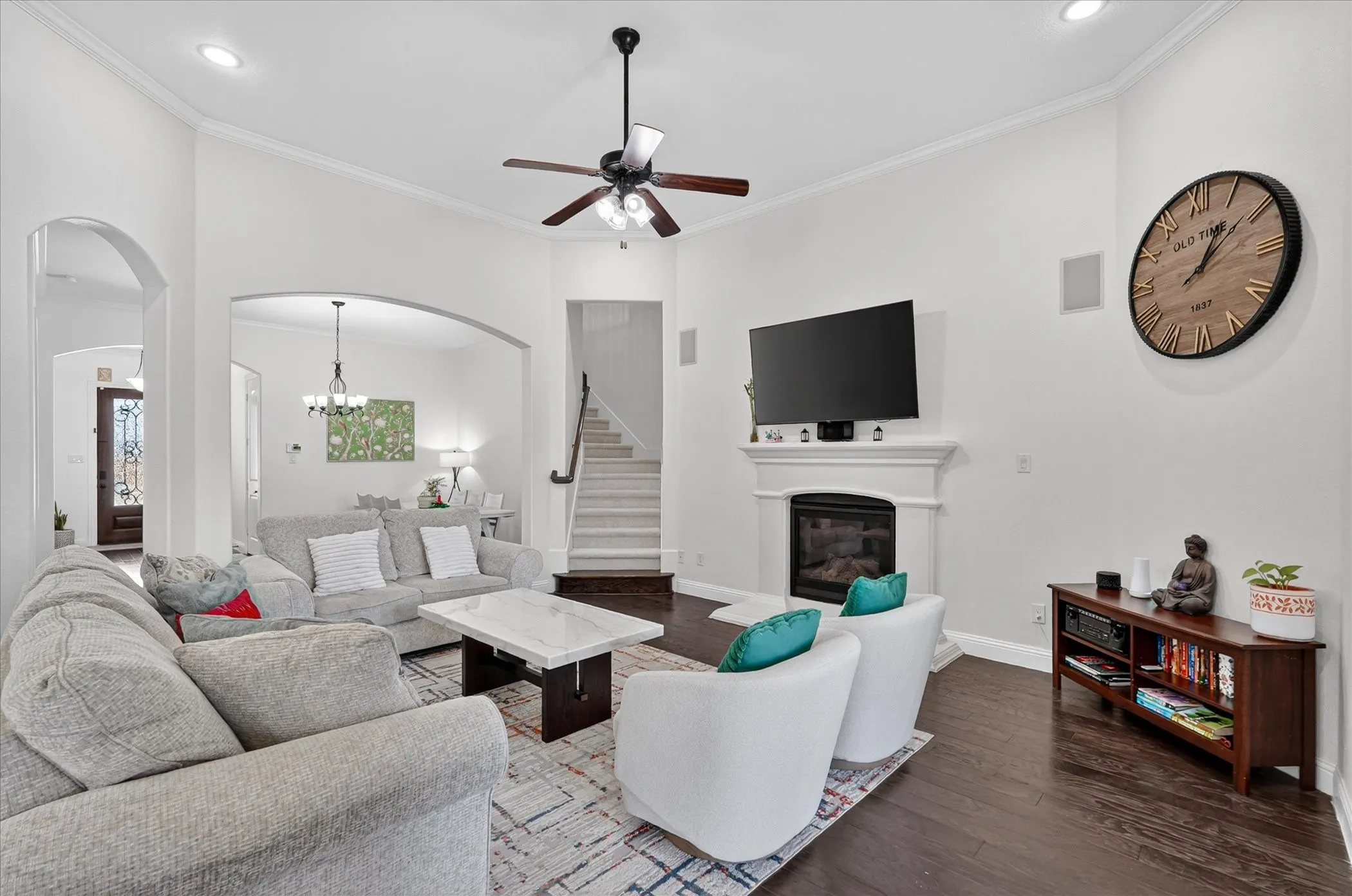 Living space featuring dark wood-finish flooring and a white mantel fireplace