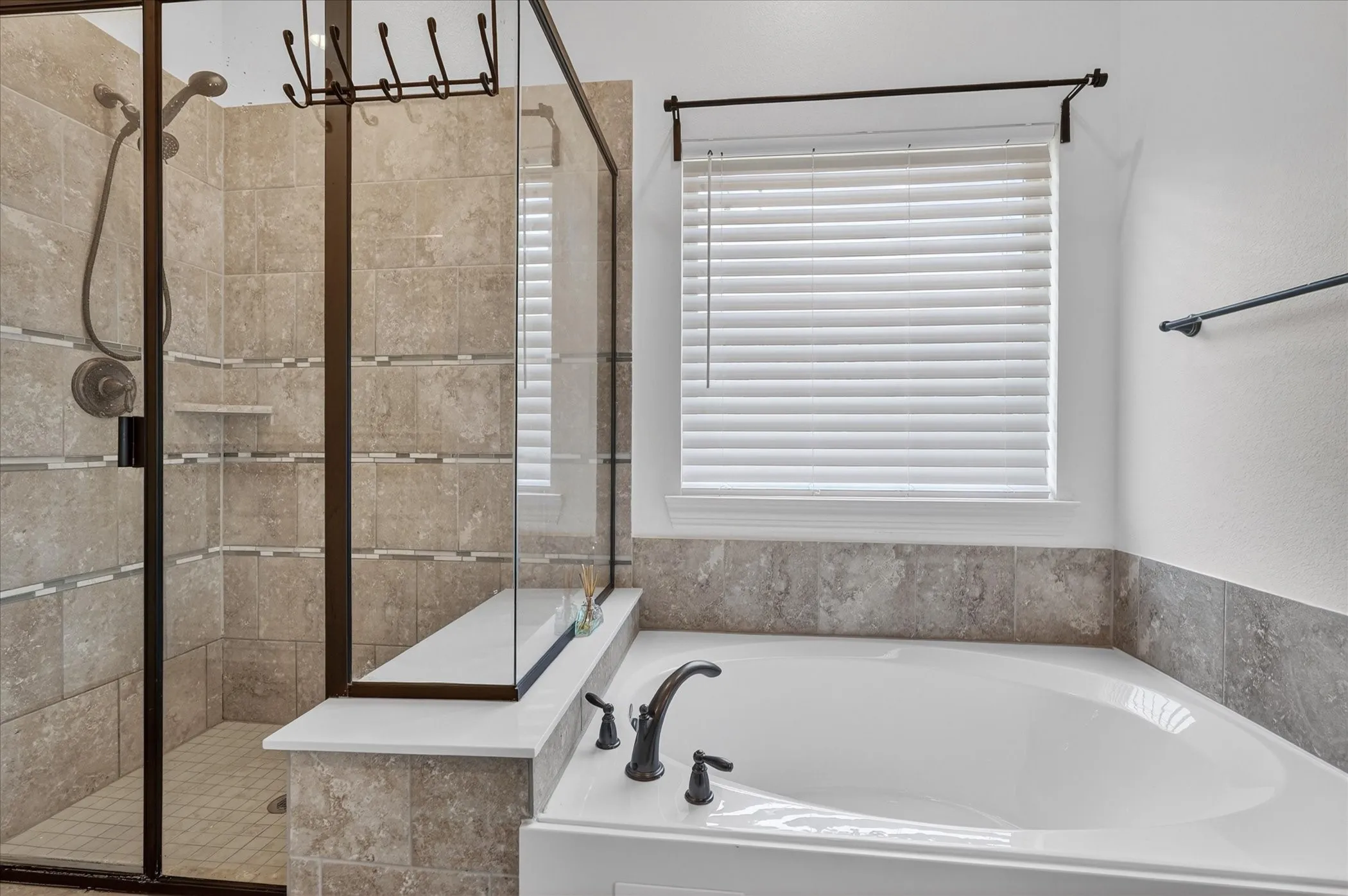 Walk-in shower with clear glass enclosure and oil-rubbed bronze fixtures