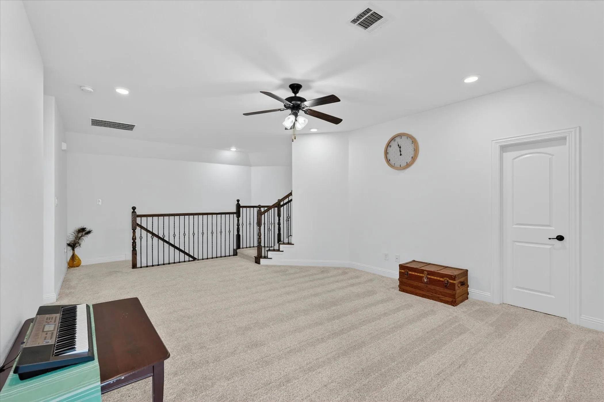 Open loft area featuring neutral-toned carpeting, a ceiling fan with integrated lighting, and recessed ceiling lights