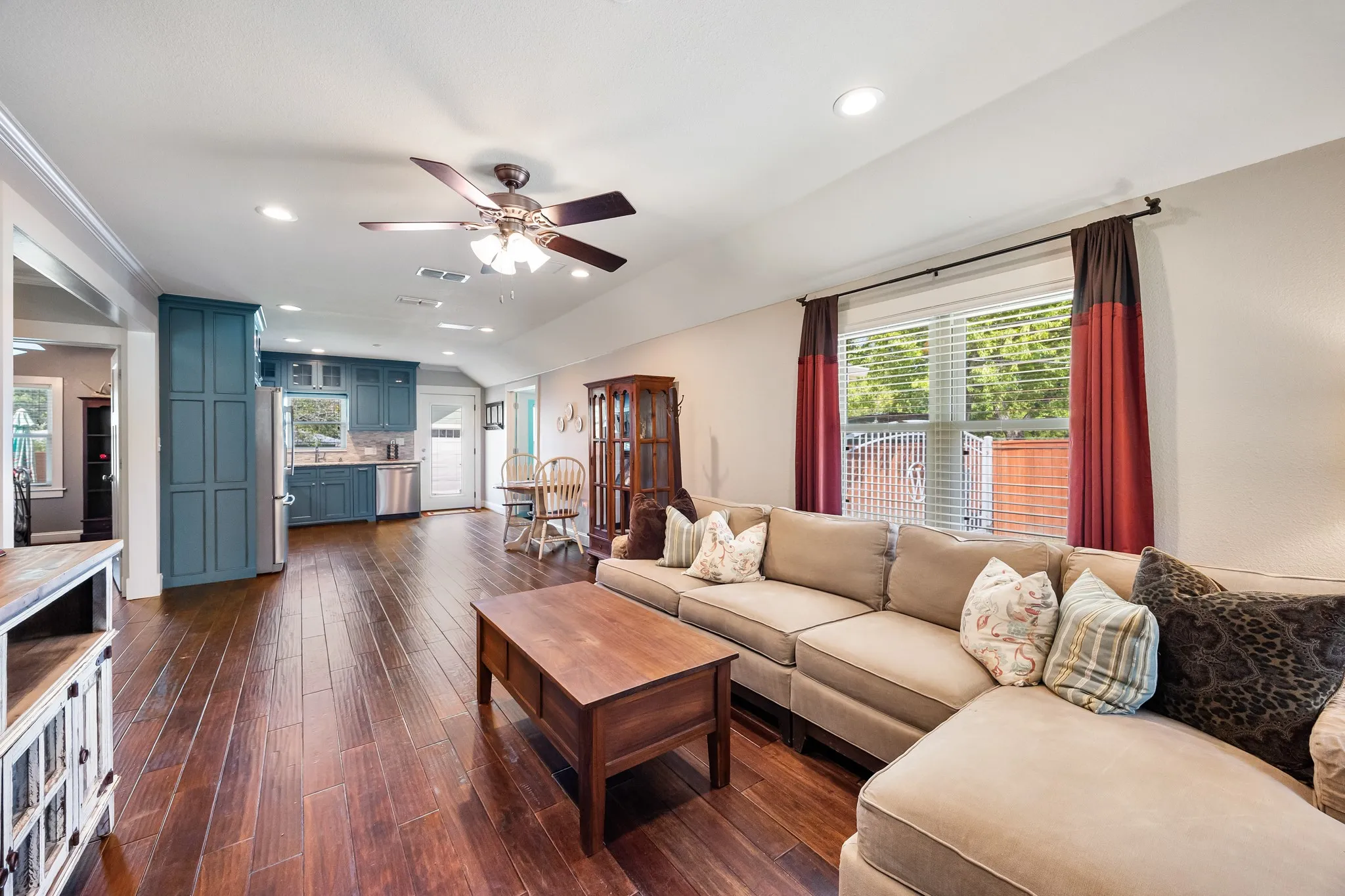 Open-concept living space featuring wood-finish flooring, a vaulted ceiling, and recessed lighting