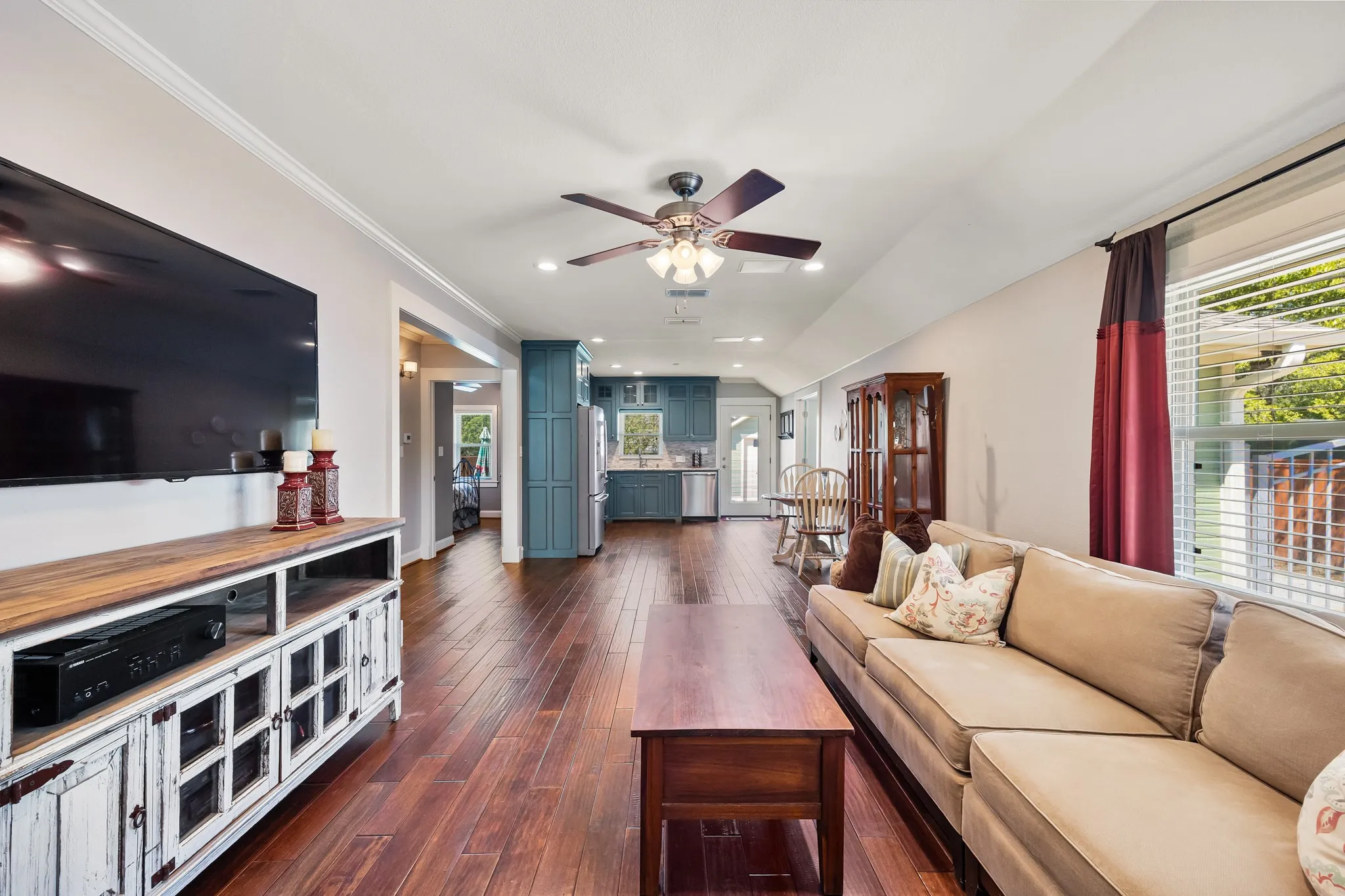 Spacious interior featuring wood-finish flooring, vaulted ceilings, and crown molding