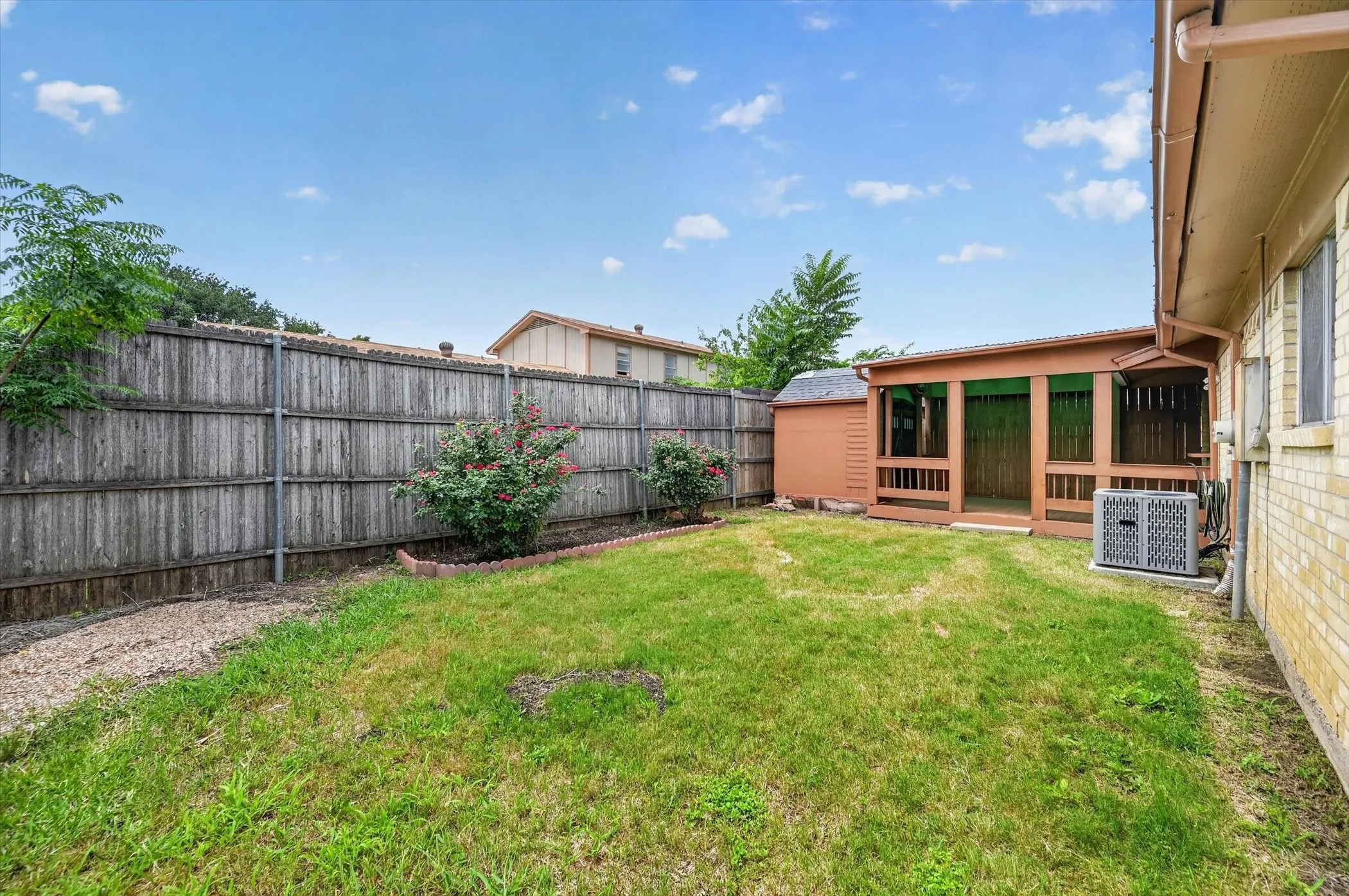 Spacious backyard featuring a covered patio, a detached storage shed, and a privacy fence