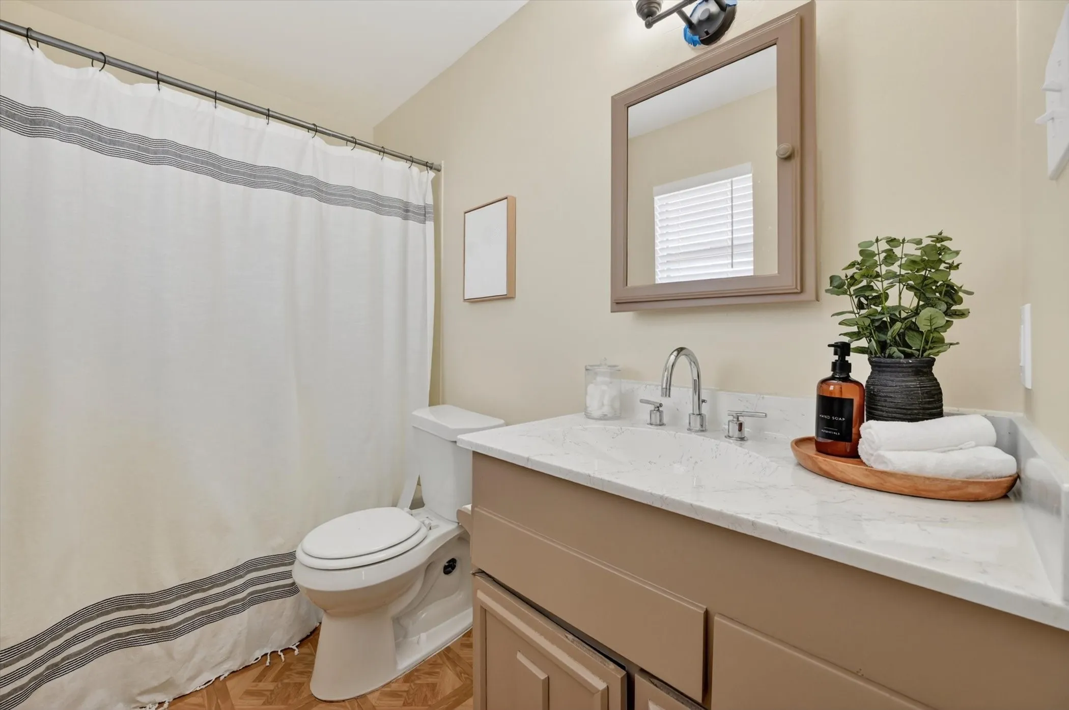 Full bathroom featuring a single vanity with a solid surface countertop, chrome faucet, and a wall-mounted medicine cabinet
