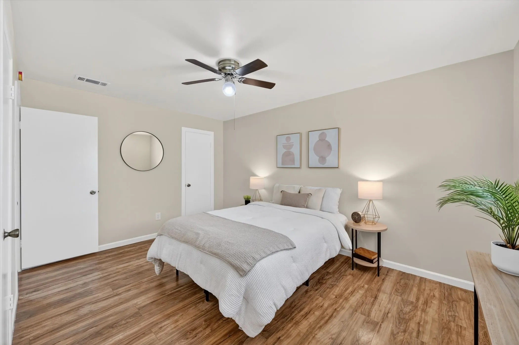 Bedroom featuring wood-finish flooring, neutral wall tones, and white trim