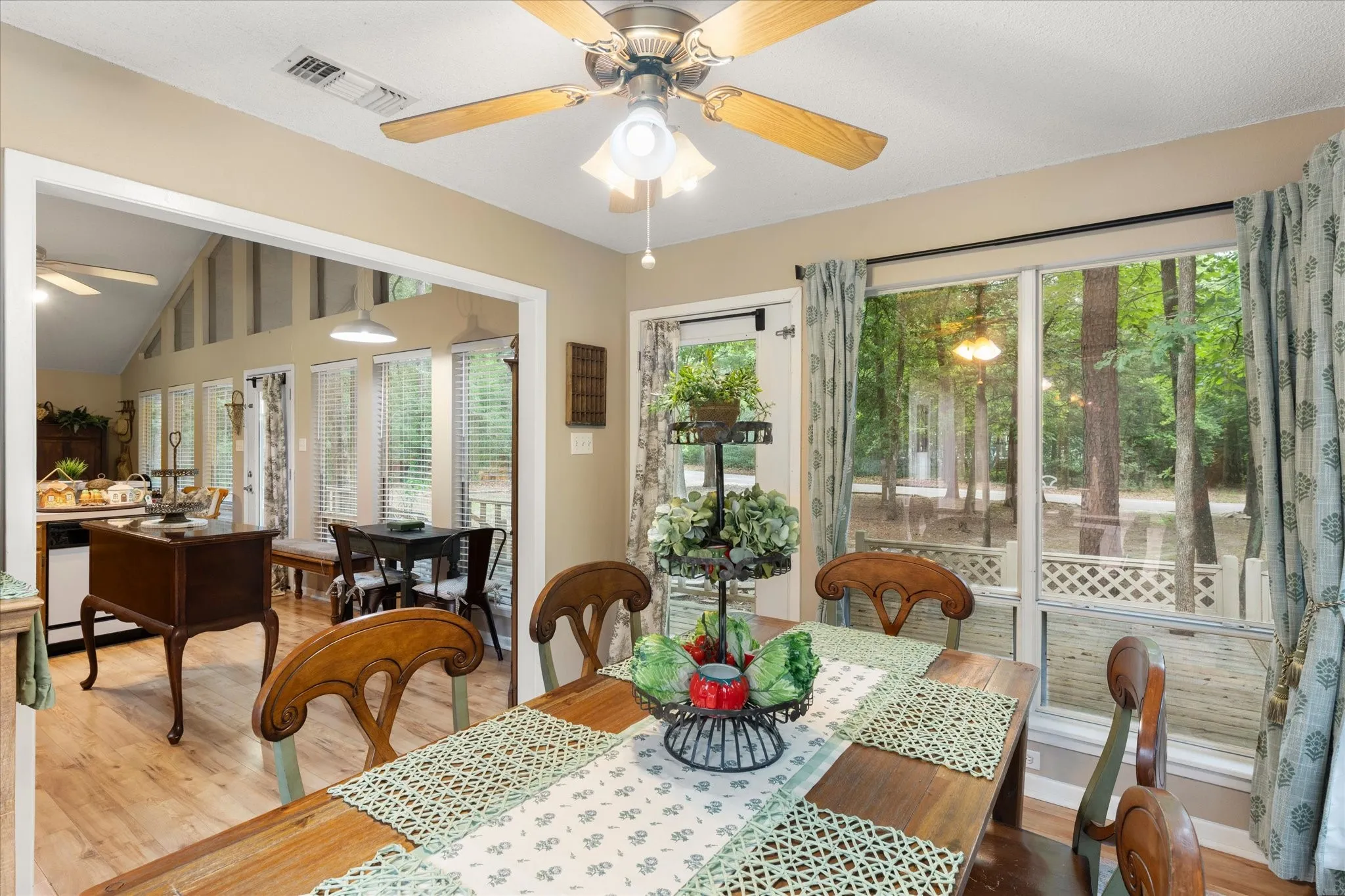Dining area featuring wood-finish flooring, a ceiling fan, and large windows with outdoor views