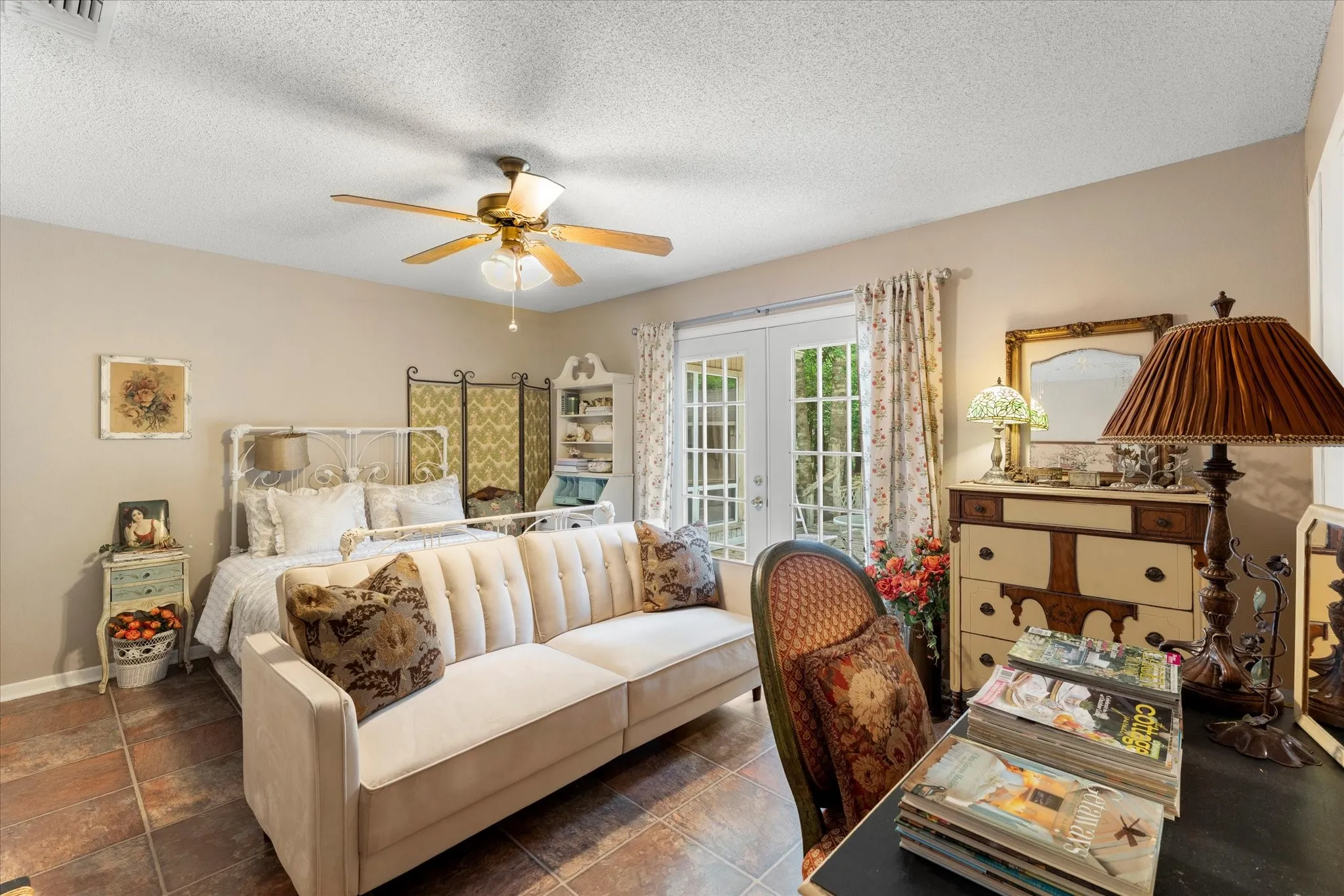 Room featuring terracotta-style floor tiles, a ceiling fan with integrated lighting, and neutral-toned wall paint