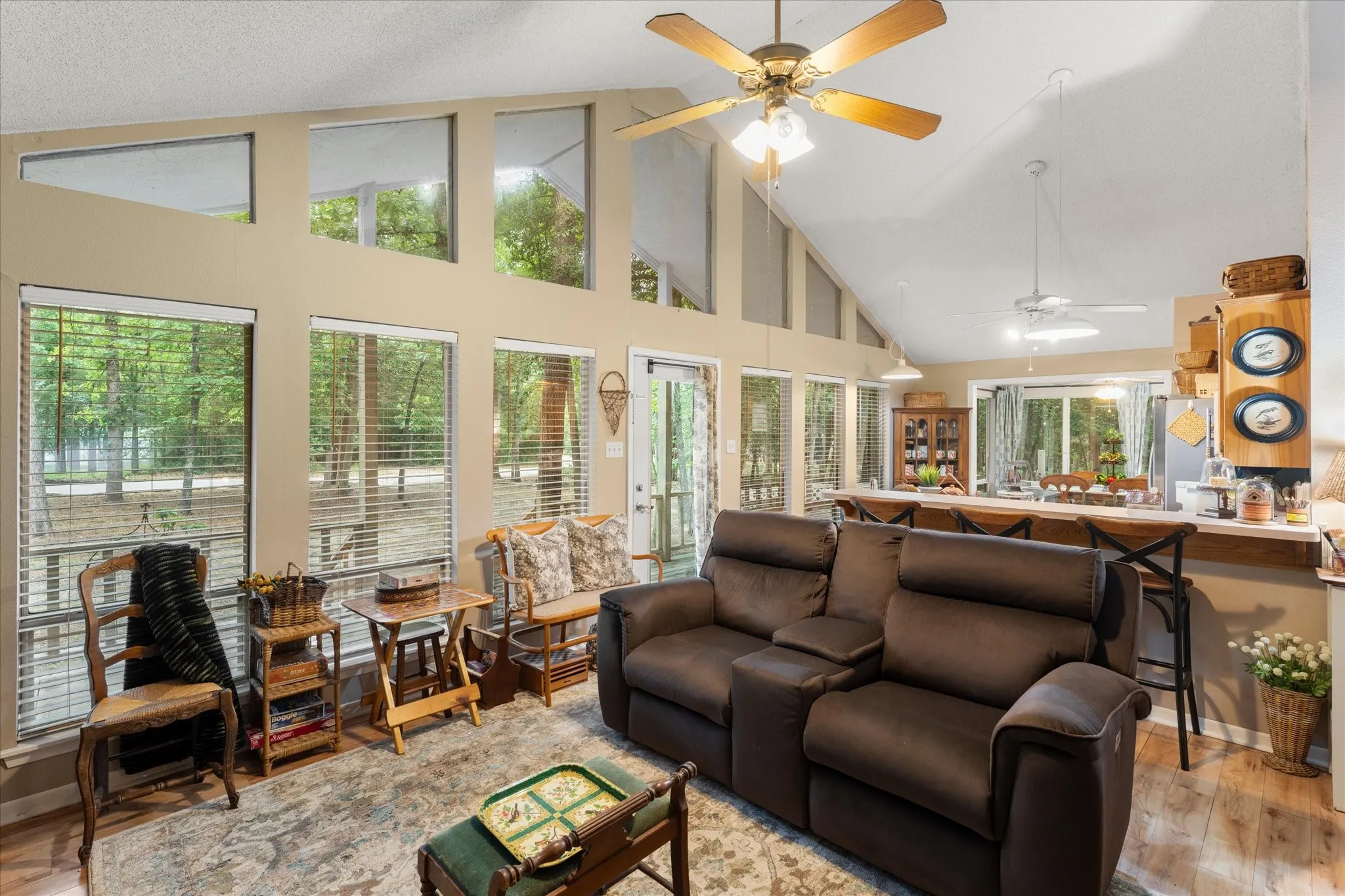 Spacious open-concept living area featuring a vaulted ceiling and an abundance of natural light