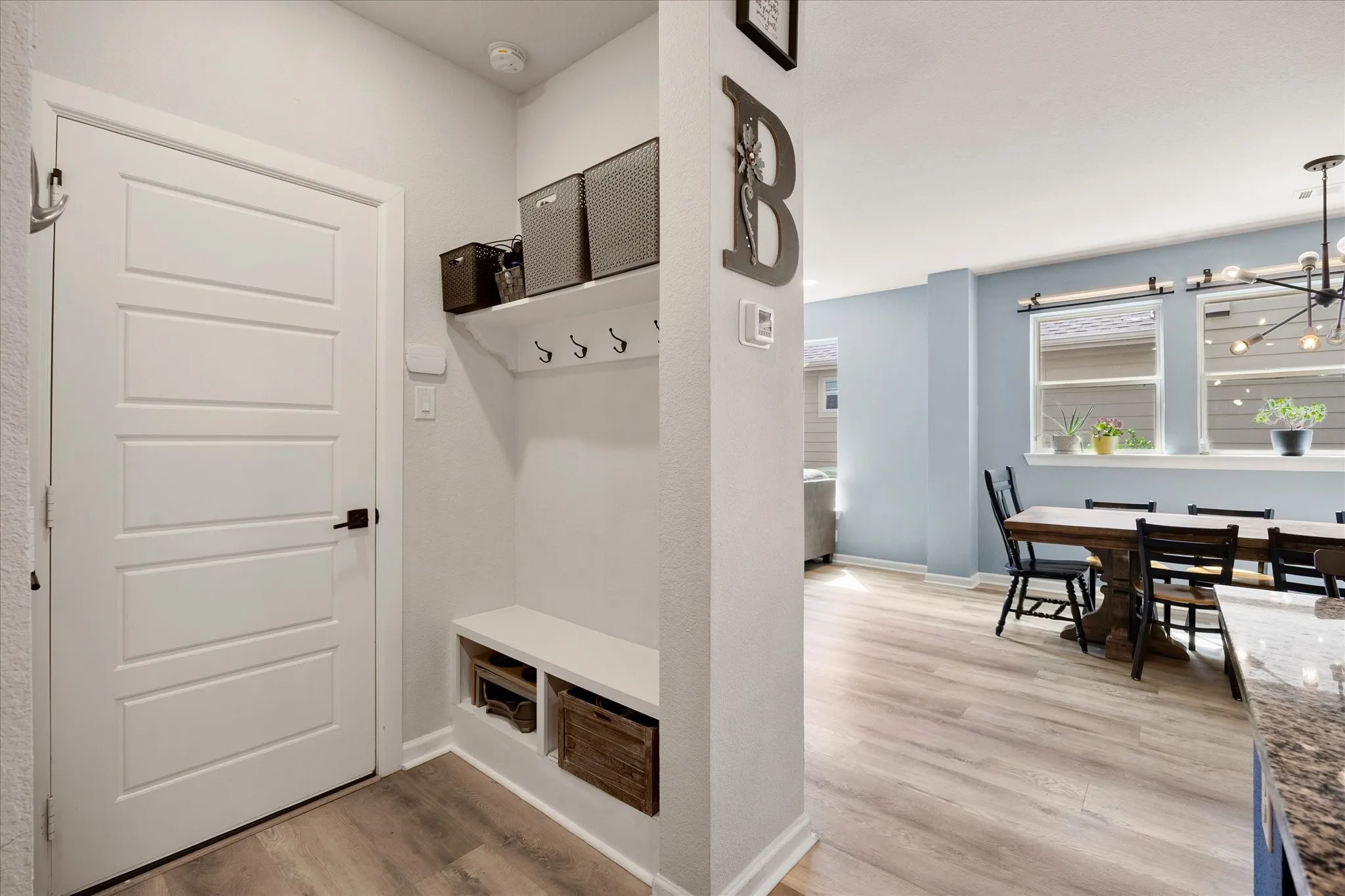 Entryway featuring a built-in bench with storage, upper shelving, and coat hooks